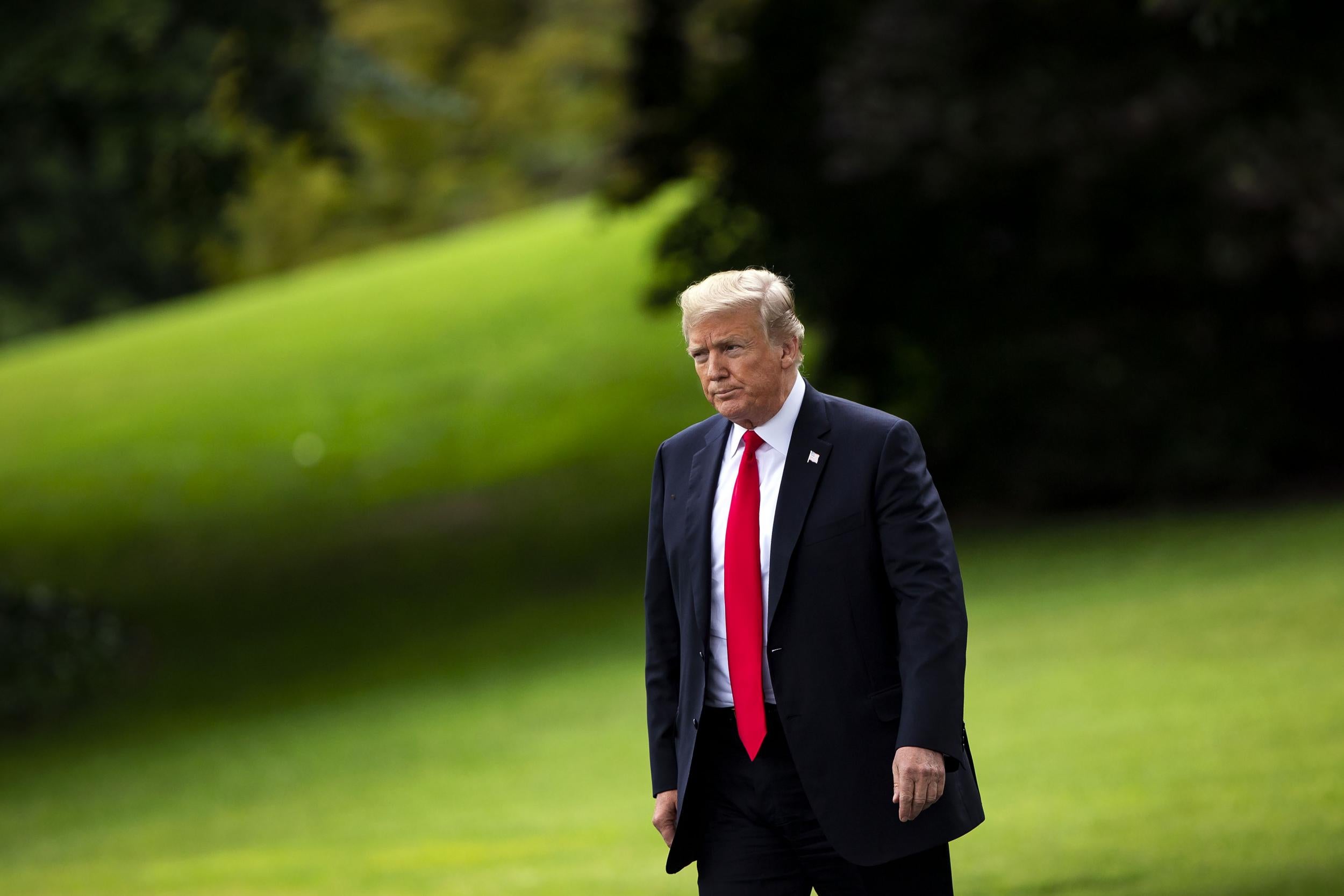 President Donald Trump walks on the South Lawn of the White House before boarding Marine One