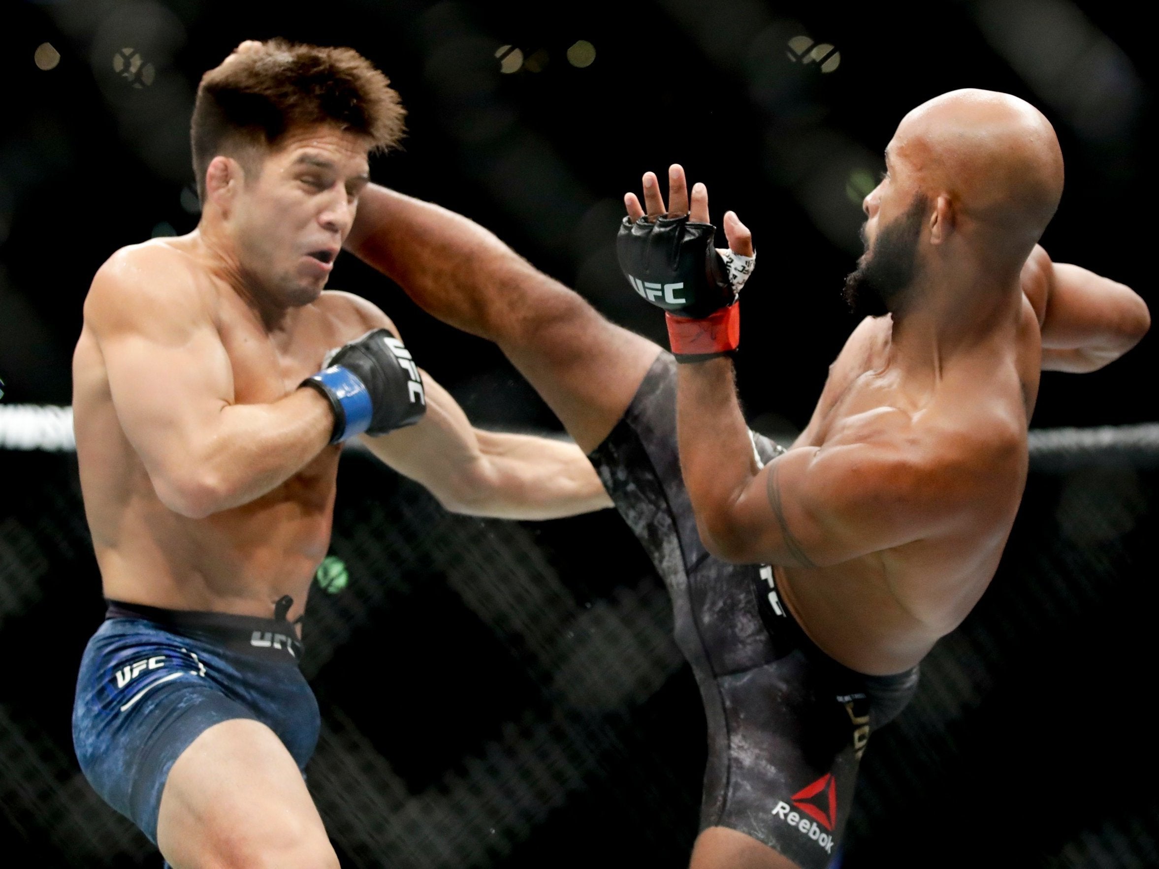 Demetrious Johnson kicks Henry Cejudo during their UFC flyweight title bout at UFC 227