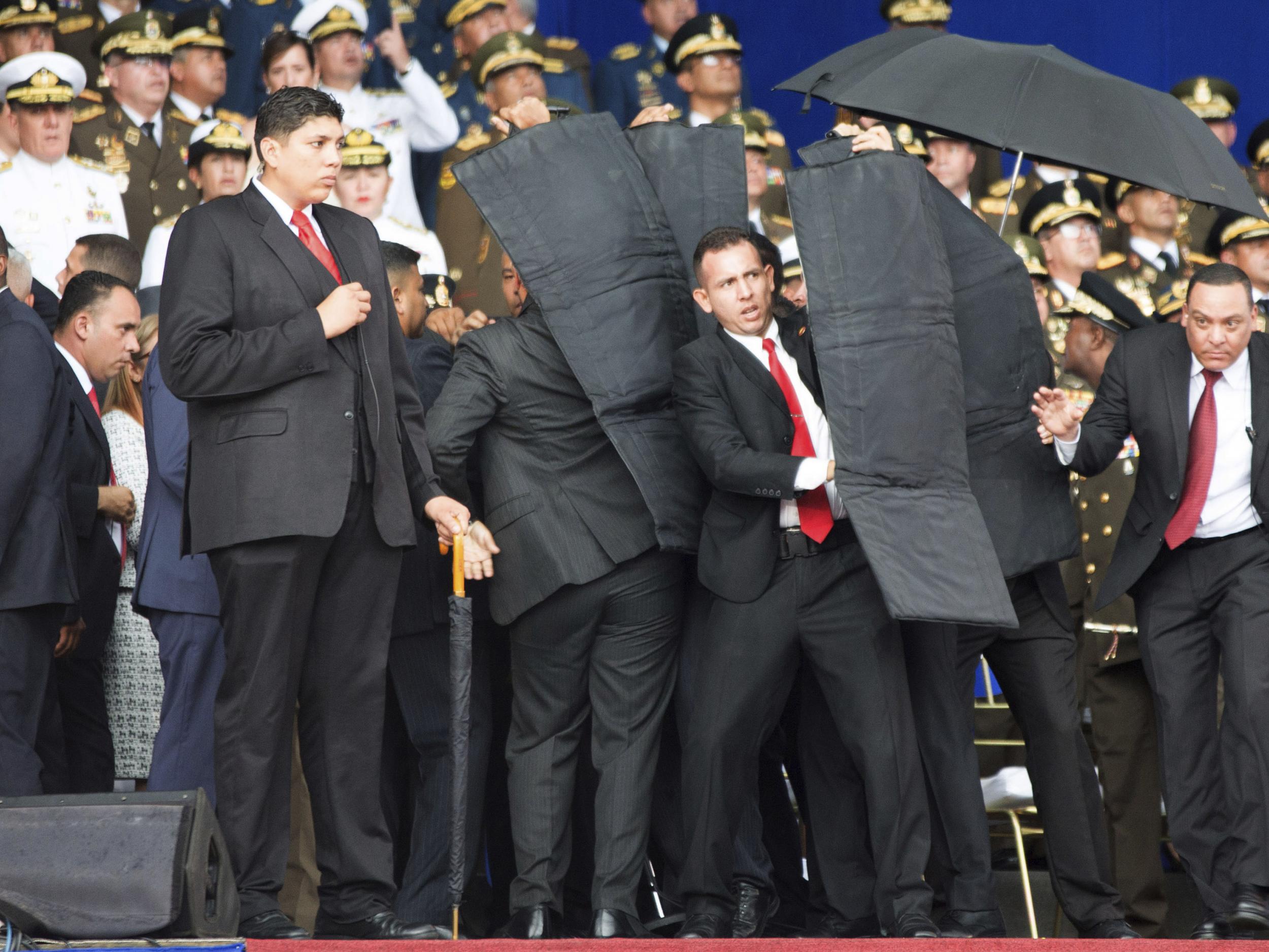 Bodyguards surround Venezuela’s President Nicolas Maduro after drones detonated near him as he was giving a speech in Caracas, Venezuela on Saturday, Aug. 4, 2018