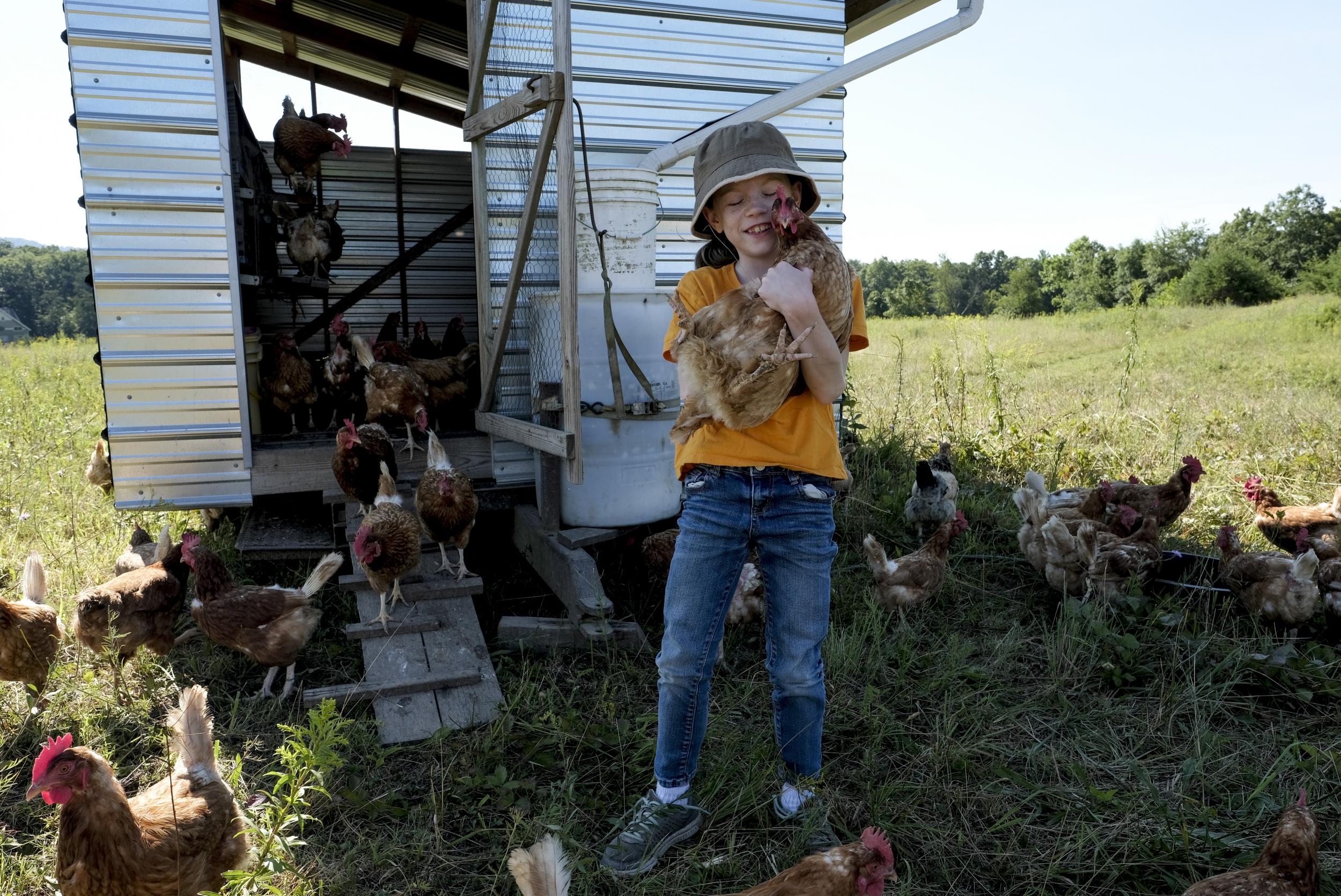 Sadie Yates, 9, hugs one of the chickens that her family raises