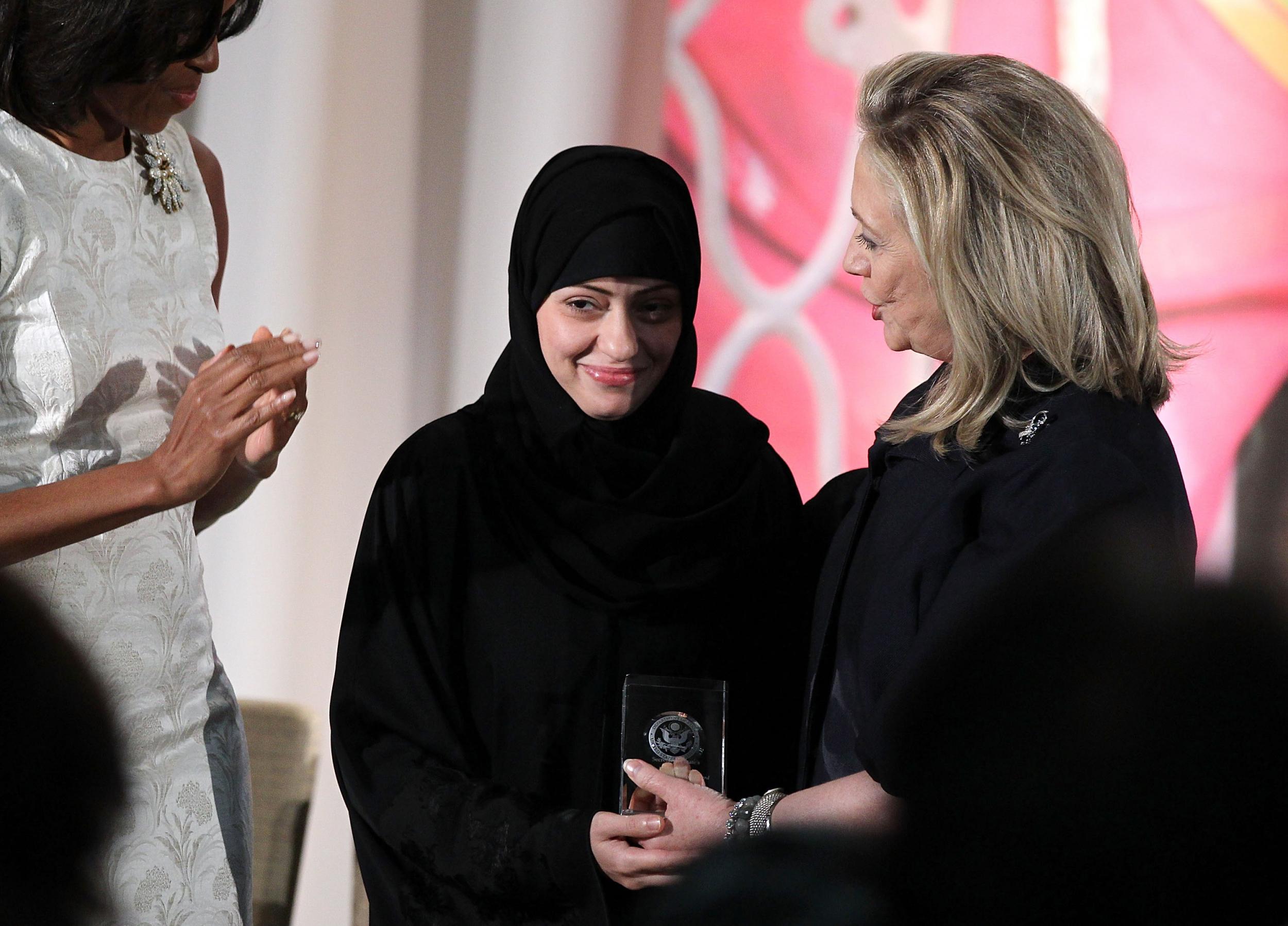 Arrested Saudi activist Samar al Badawi (C) with Michelle Obama (L) and Hillary Clinton (R) during a ceremony at the US state department on 8 March 2012 in Washington DC