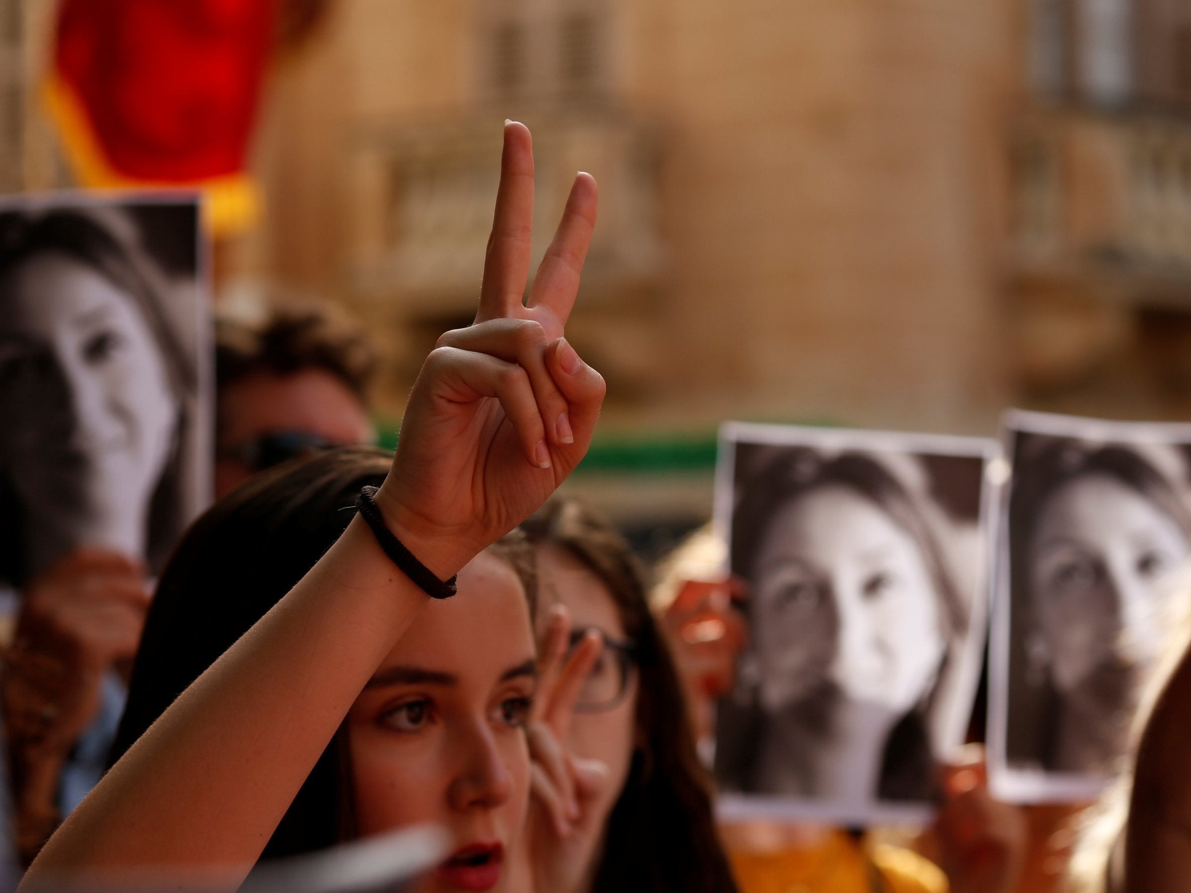 People attend a vigil marking nine months since her assassination last month