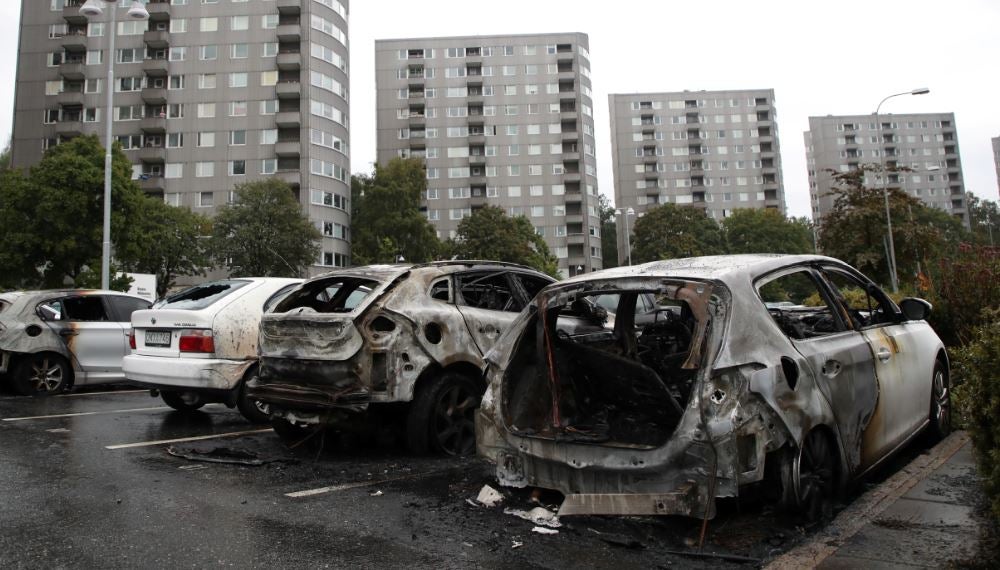 Burned cars are pictured at Frolunda Square in Gothenburg