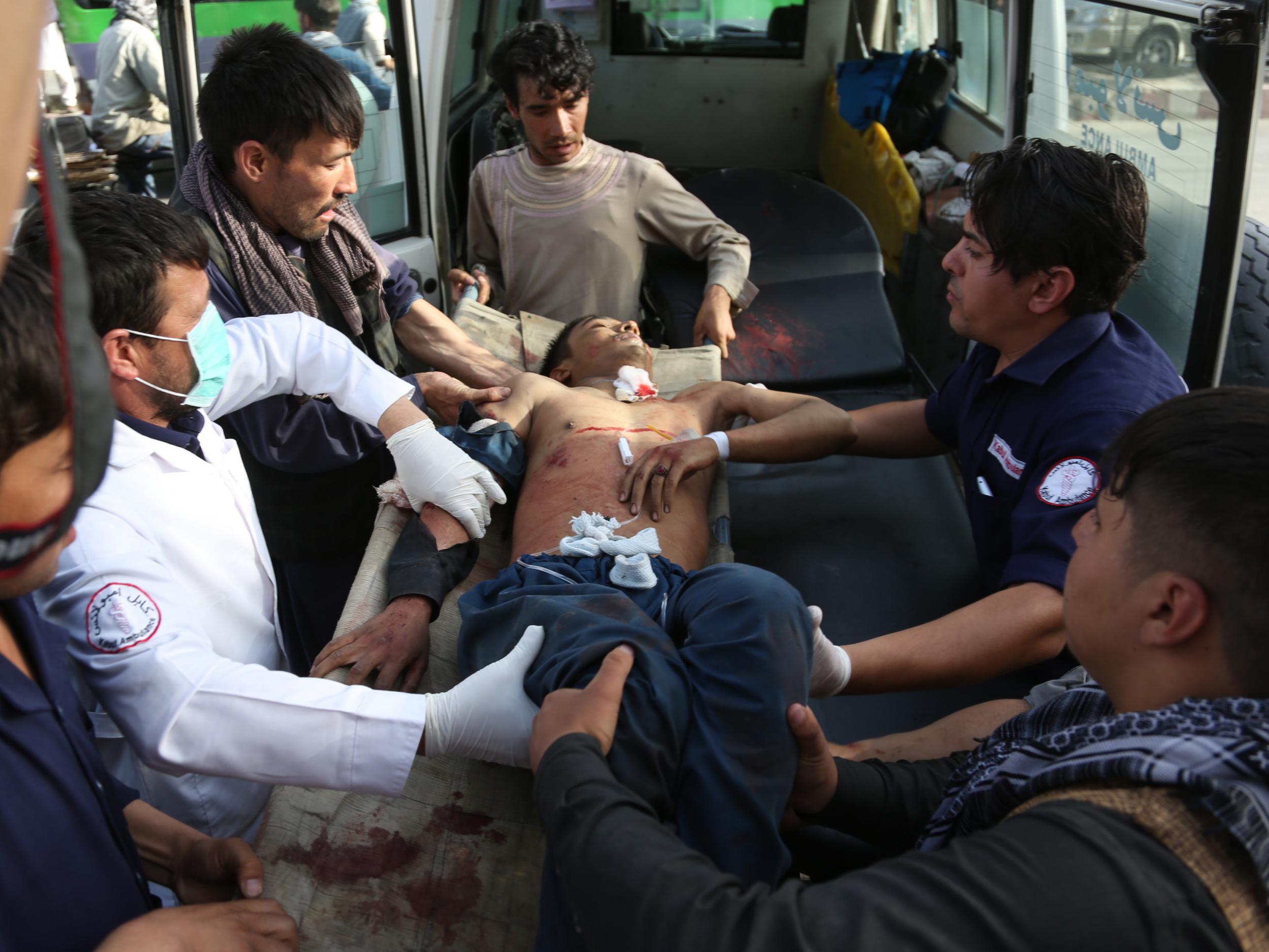 A man who was injured in suicide bombing that targeted a training class in a private building in the Shiite neighborhood of Dasht-i Barcha is placed in an ambulance, 15 August 2018