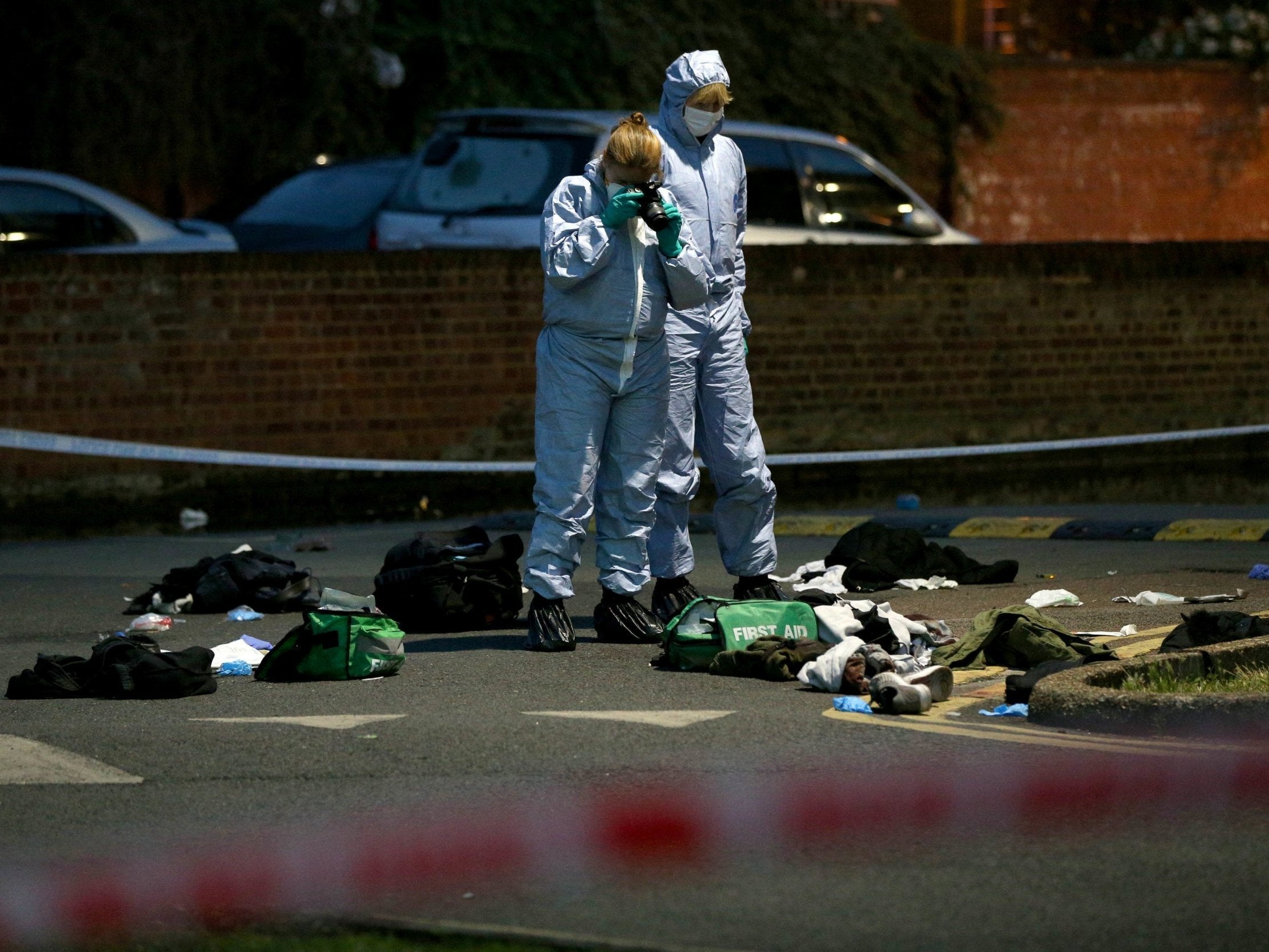 Forensics officers inspect the area outside Landor House, Camberwell, London, after four people were taken to hospital with stab wounds