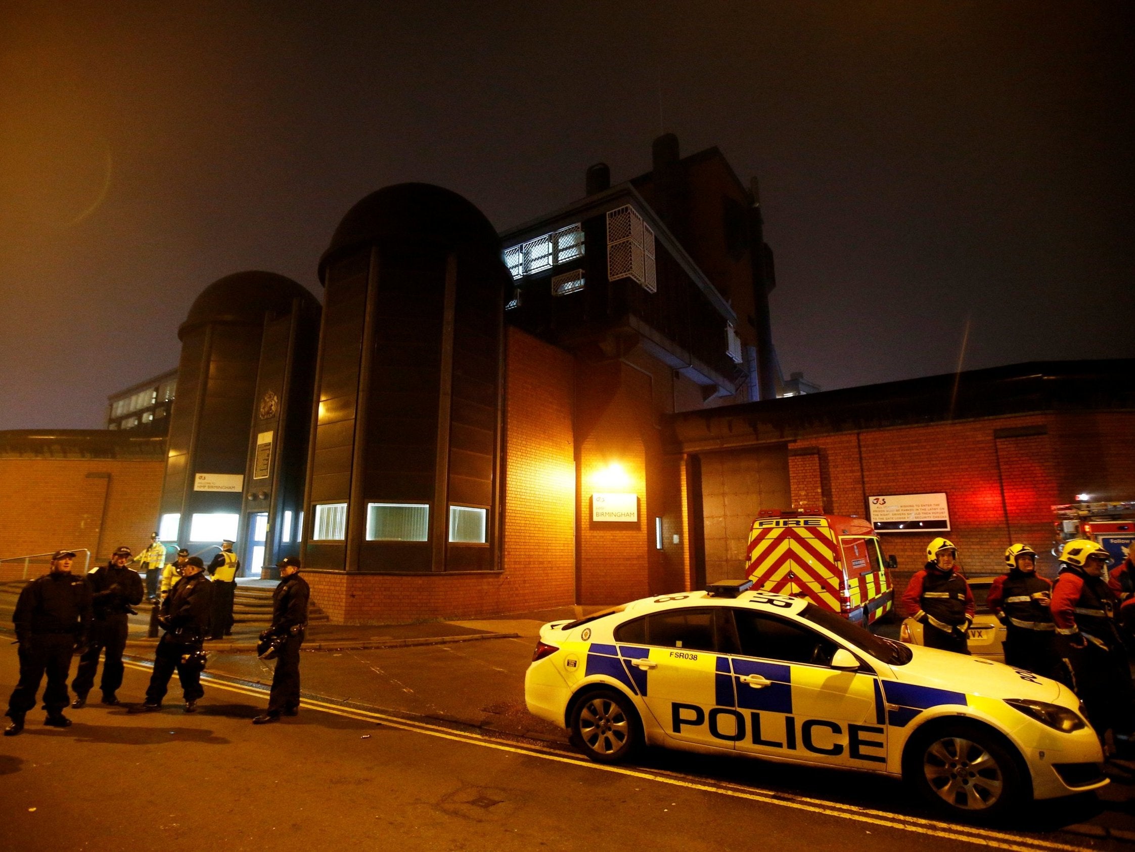 Police officers and firemen stand outside Winson Green prison, run by security firm G4S, after a serious disturbance broke out on 16 December 2016