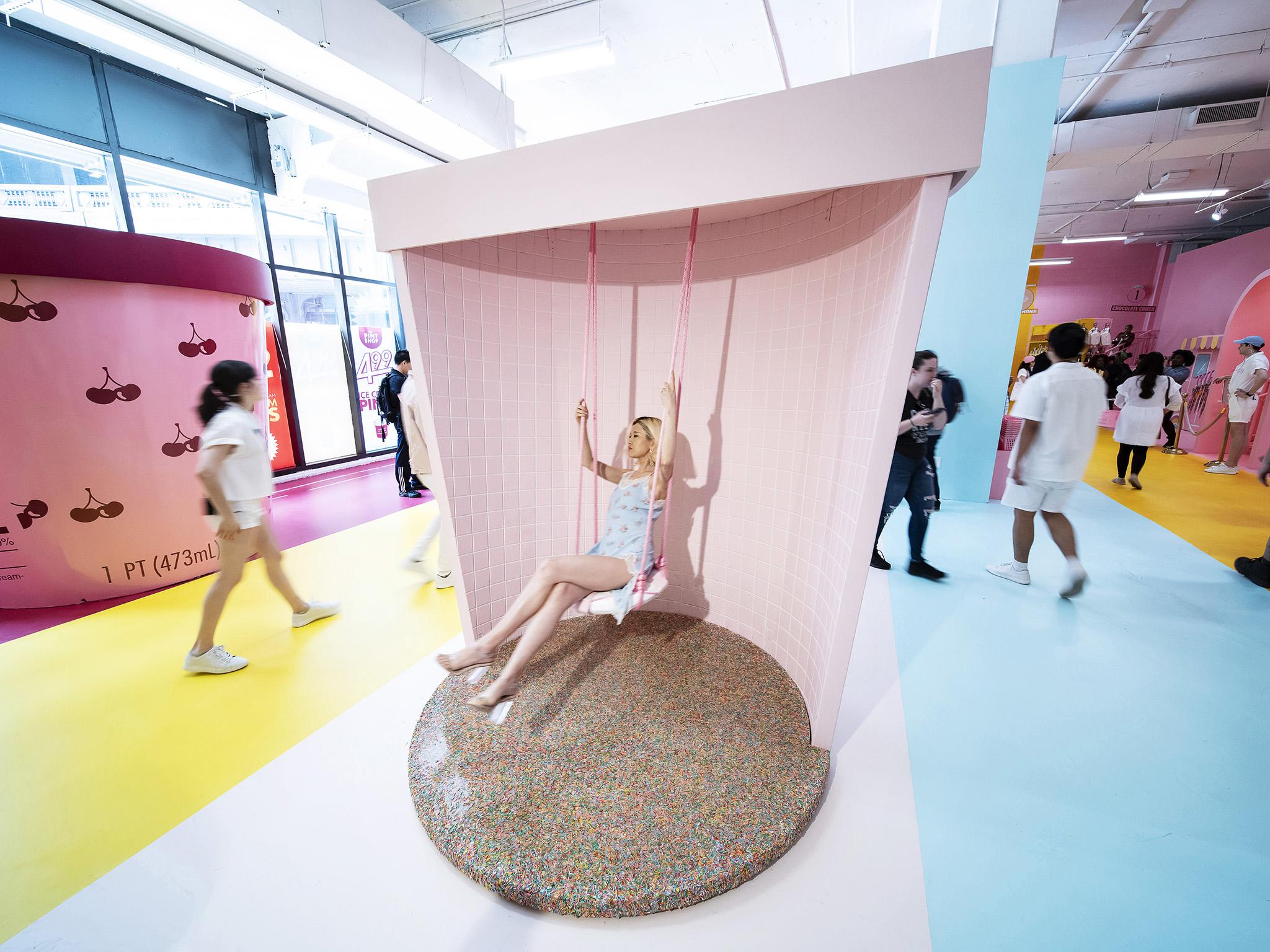 Saina Kam poses for photos on the swing inside a giant ice cream pint bucket