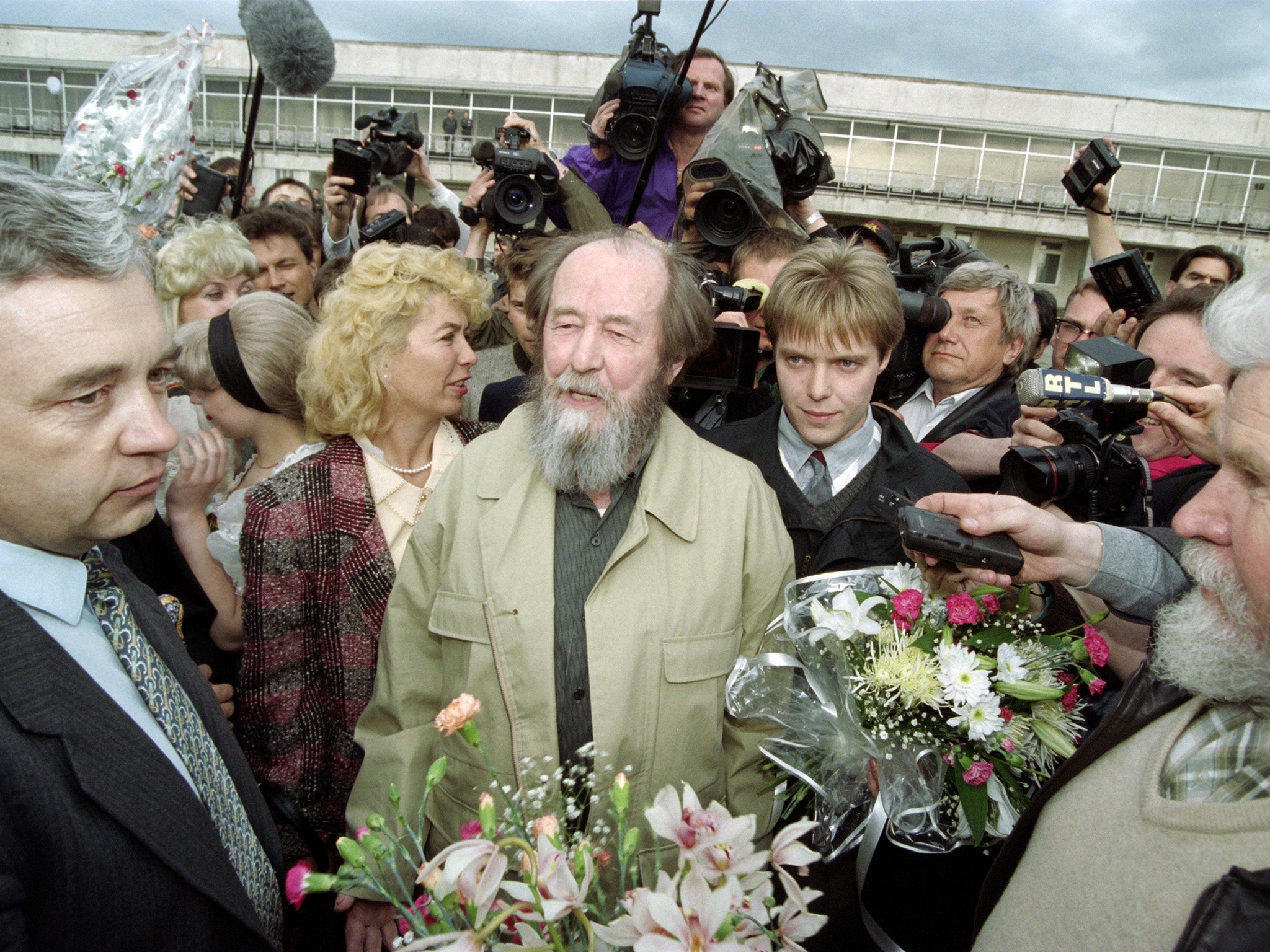 Solzhenitsyn arrives at Vladivostok airport on 27 May 1994, following 20 years of exile. Standing behind him is his son Yermolai