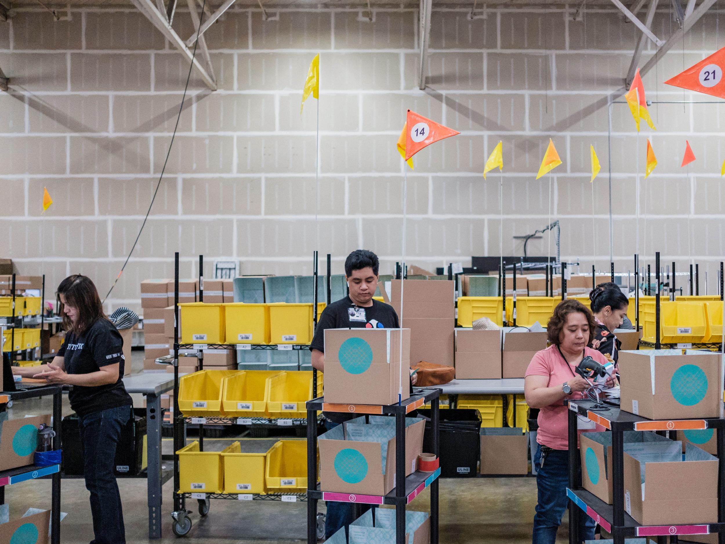 ‘Pickers’ load their carts with boxes before heading out into the rows of clothing to pack orders