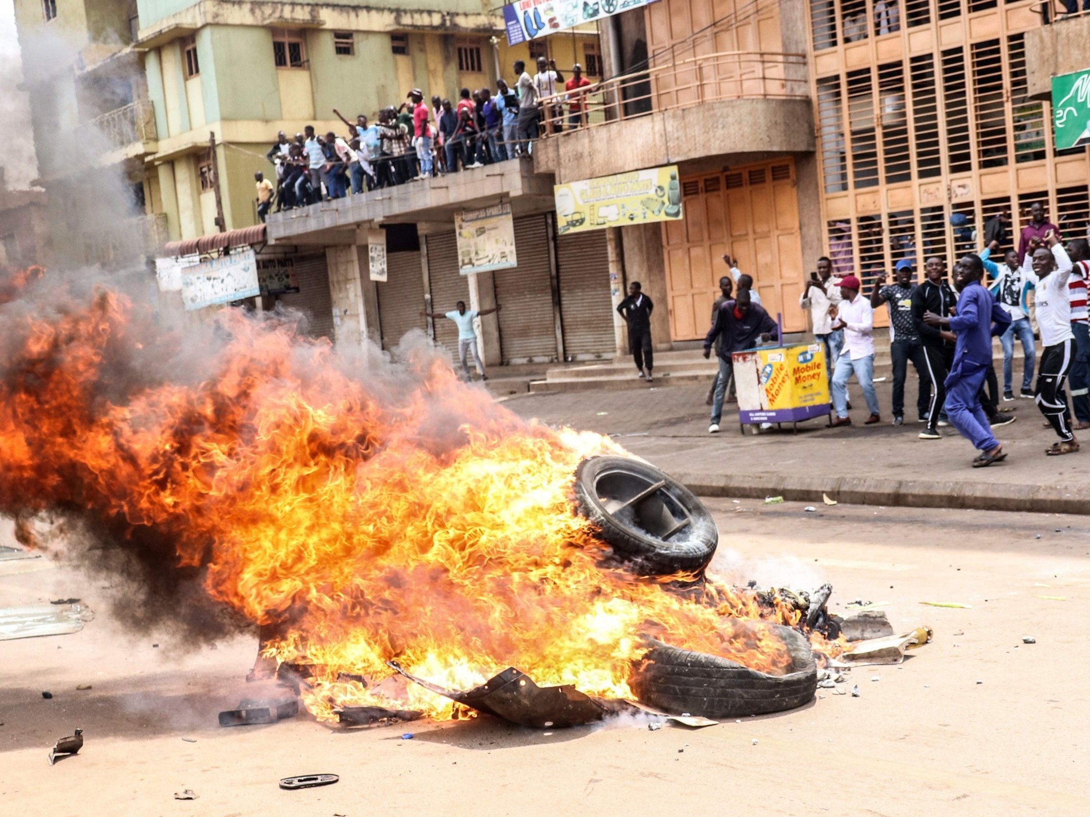 Protesters set a bonfire on a street to demand the release of Bobi Wine