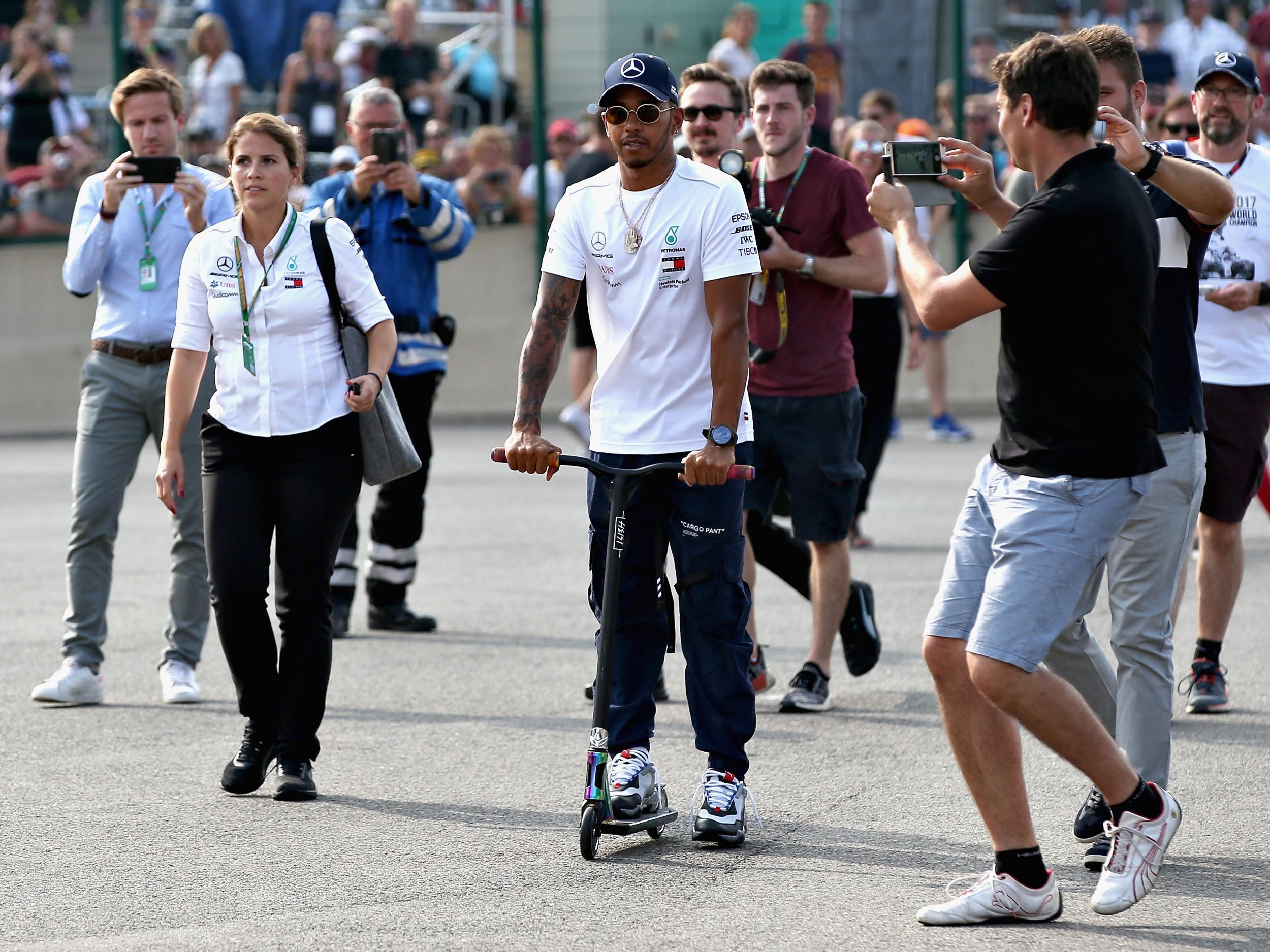 Hamilton makes his way around the paddock in style