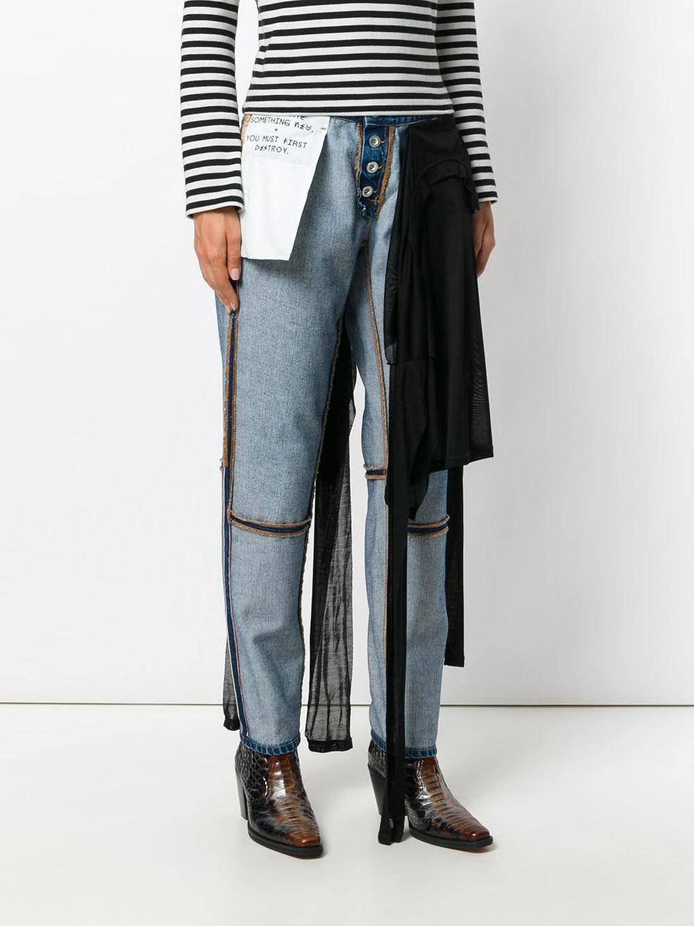 The denim jeans have visible seams and pockets (Farfetch)