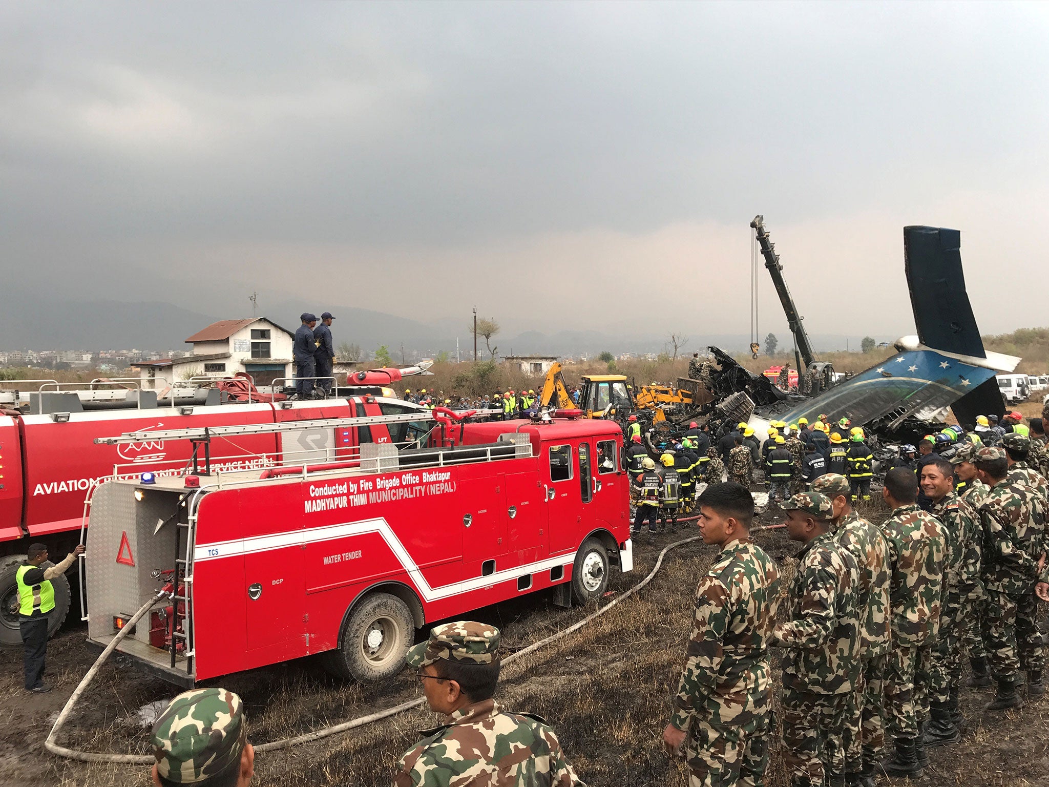 Wreckage of the US Bangla plane surrounded by rescue workers after its crash in March