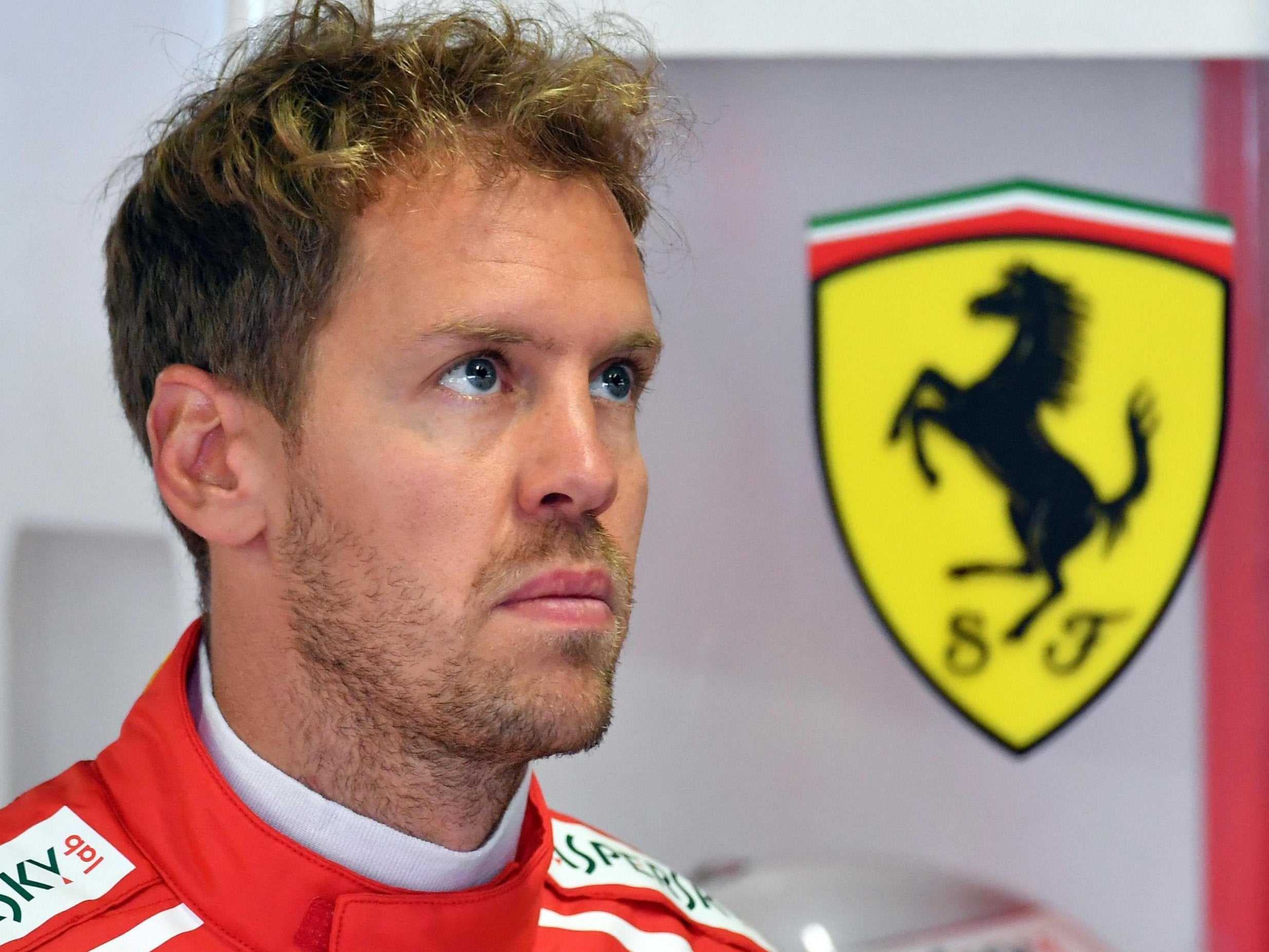 Sebastian Vettel watches on from the paddock