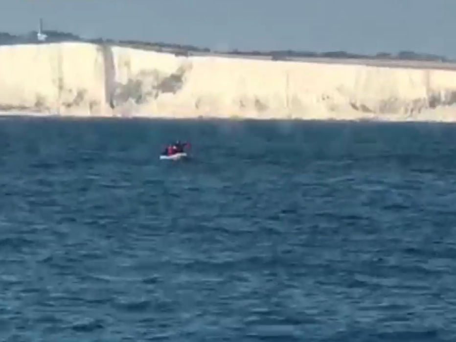 The asylum seekers flag down the boat using a t-shirt tied to oar