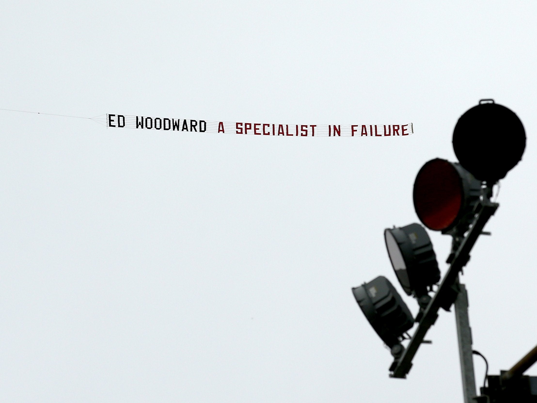 A banner reading 'Ed Woodward a specialist in failure!' is flown over Turf Moor