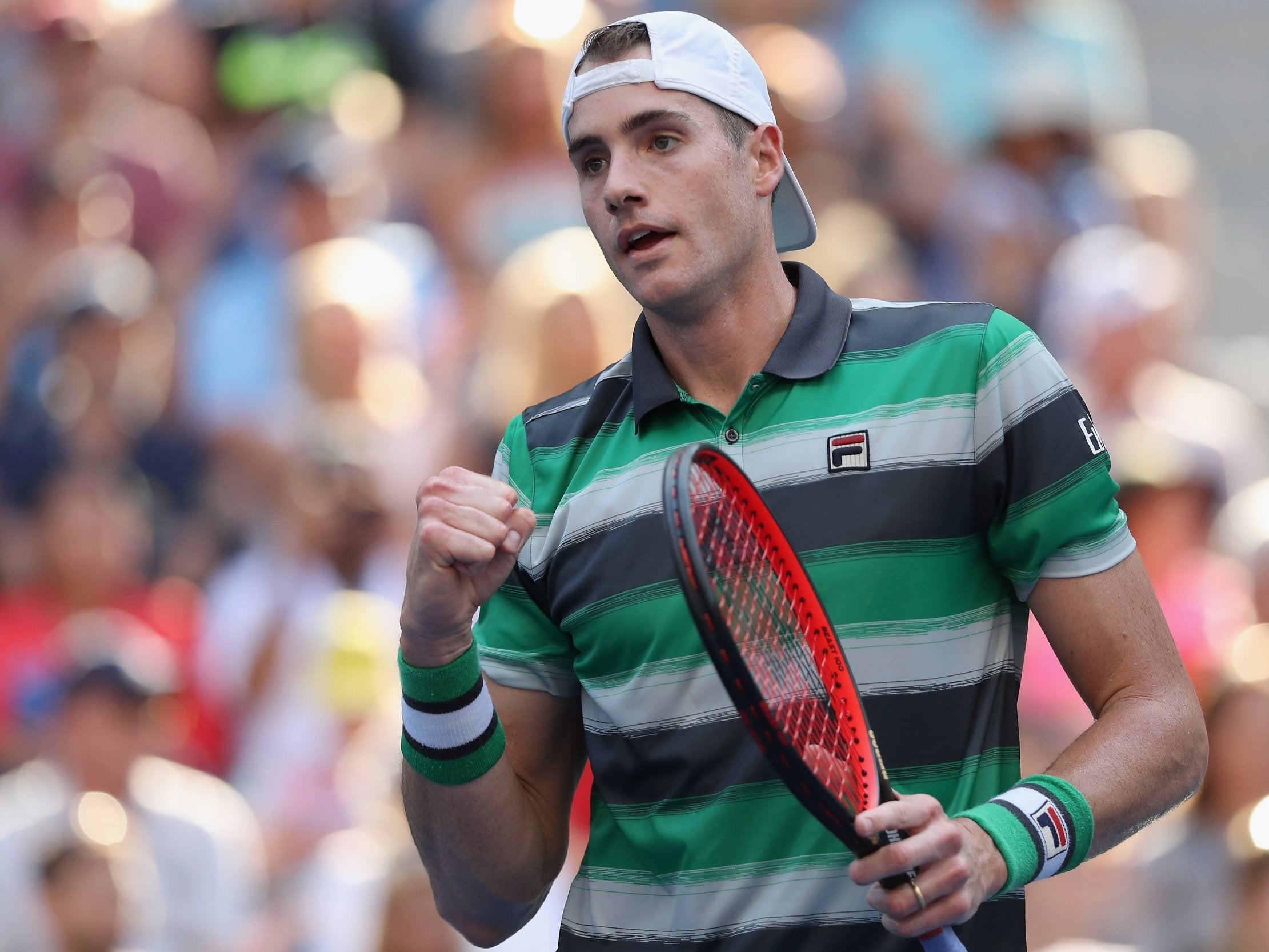 John Isner celebrates after beating Milos Raonic