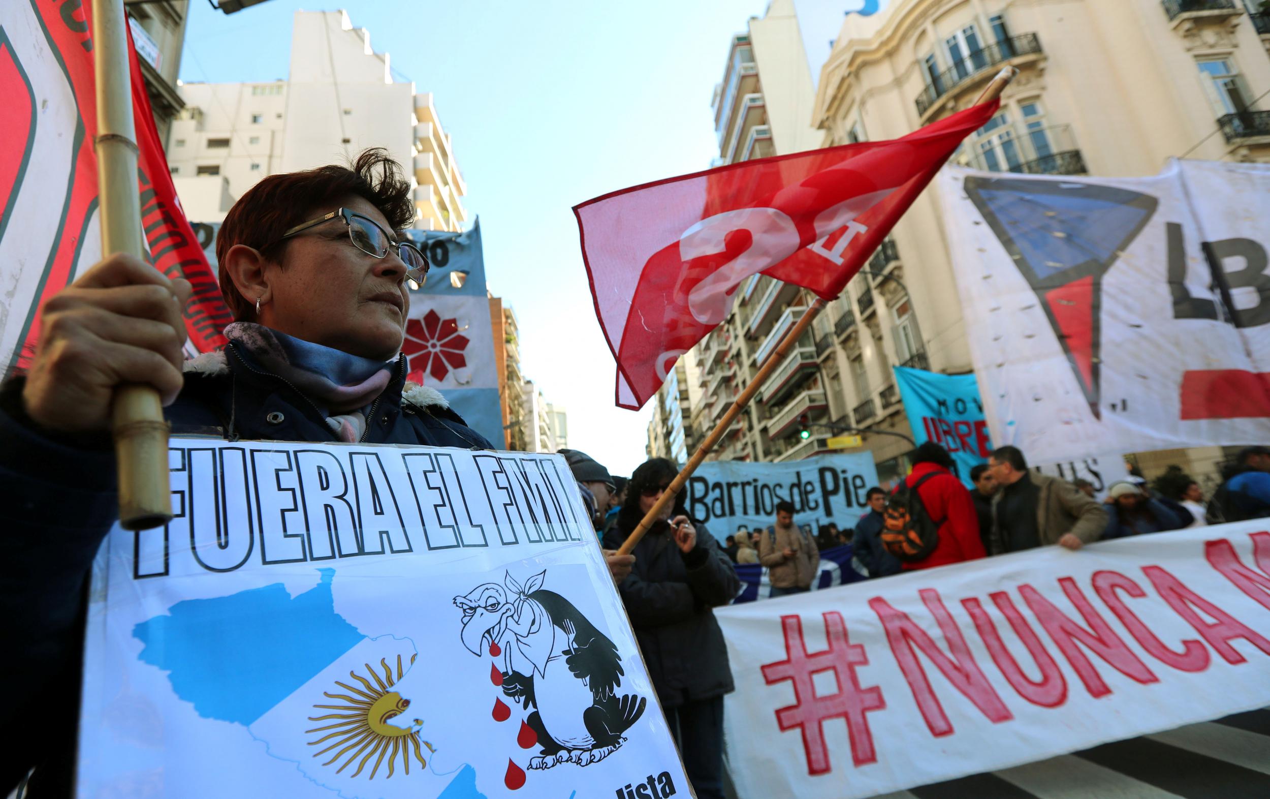 A demonstrator holds a sign that reads "IMF (International Monetary Fund), get out" during a protest against the G20 Meeting of Finance Ministers in Buenos Aires, Argentina, July 21, 2018.