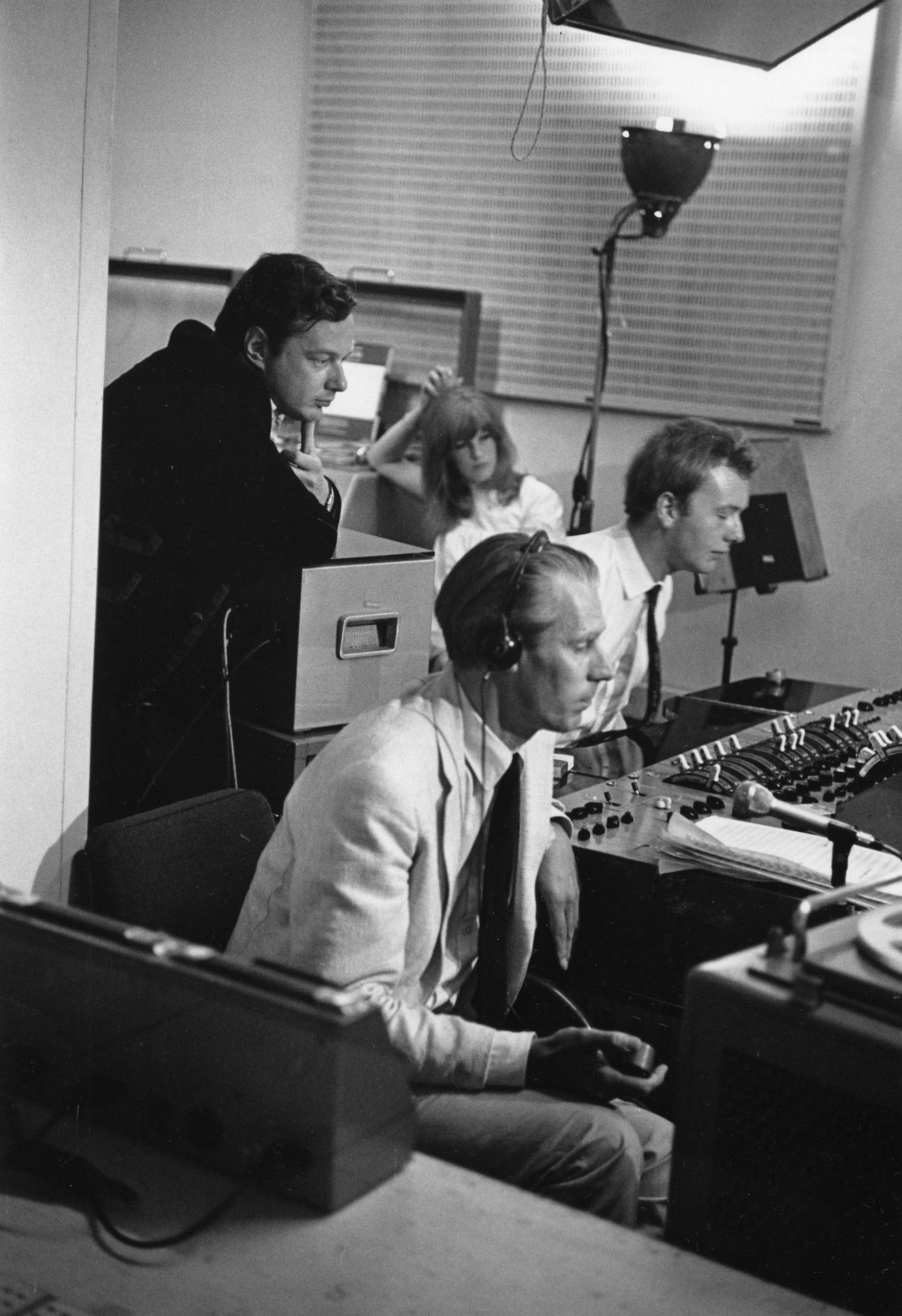 Brian Epstein (left), George Martin, and Geoff Emerick (right) in the control booth at EMI Studios during the Our World global simulcast (AP)