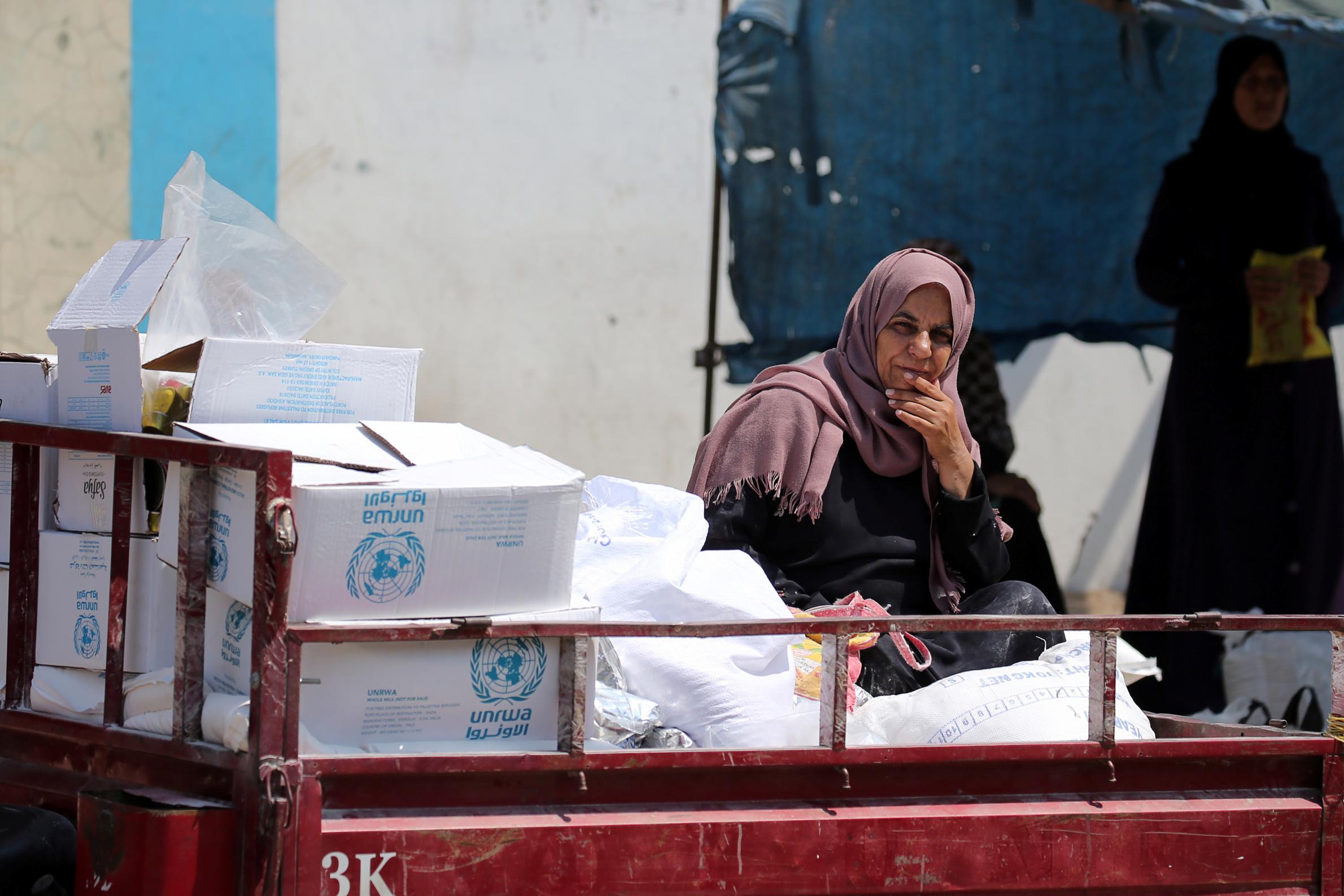 A Palestinian woman sits in a United Nations vehicle loaded with aid supplies in Gaza Strip