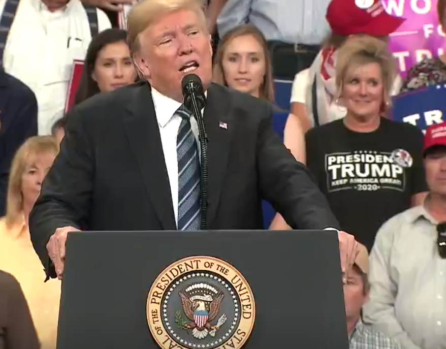 Woman in blue dress and woman in Trump T-shirt replace the two men