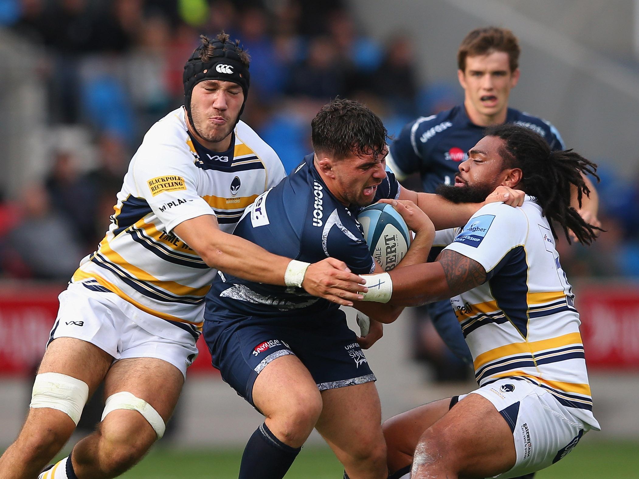 Cameron Neild is tackled by Joe Taufete'e and Andrew Kitchener