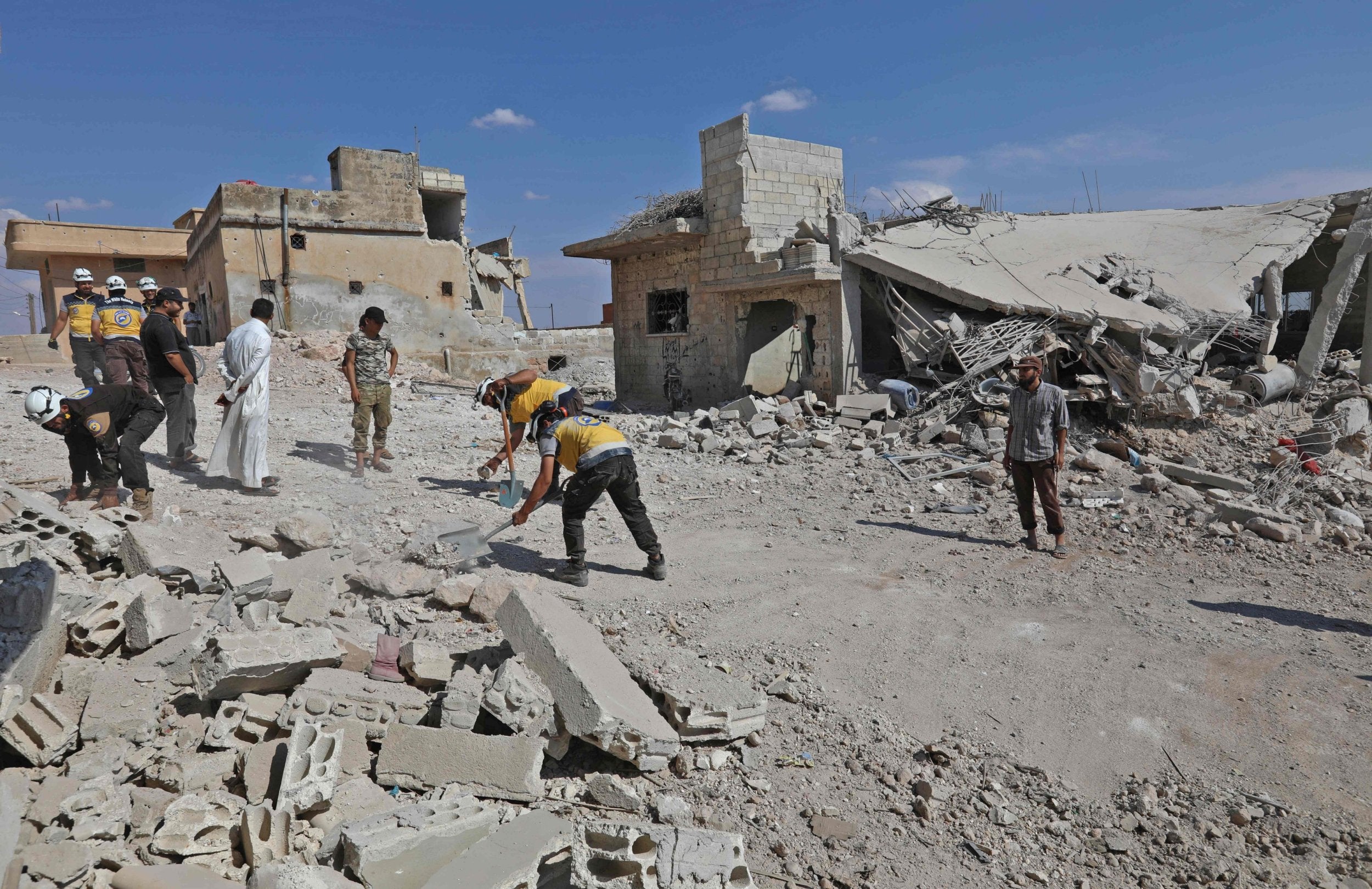 Rescuers work amid the destruction caused by Syrian government bombardment of the town of Al Habit in rebel-held Idlib province