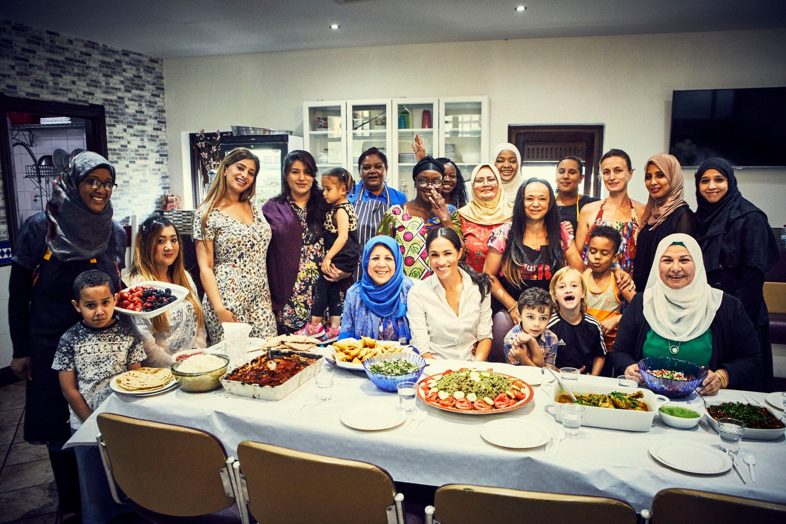 The Duchess of Sussex poses with the women of the Hubb Community Kitchen at the Al Manaar Muslim Cultural Heritage Centre in London