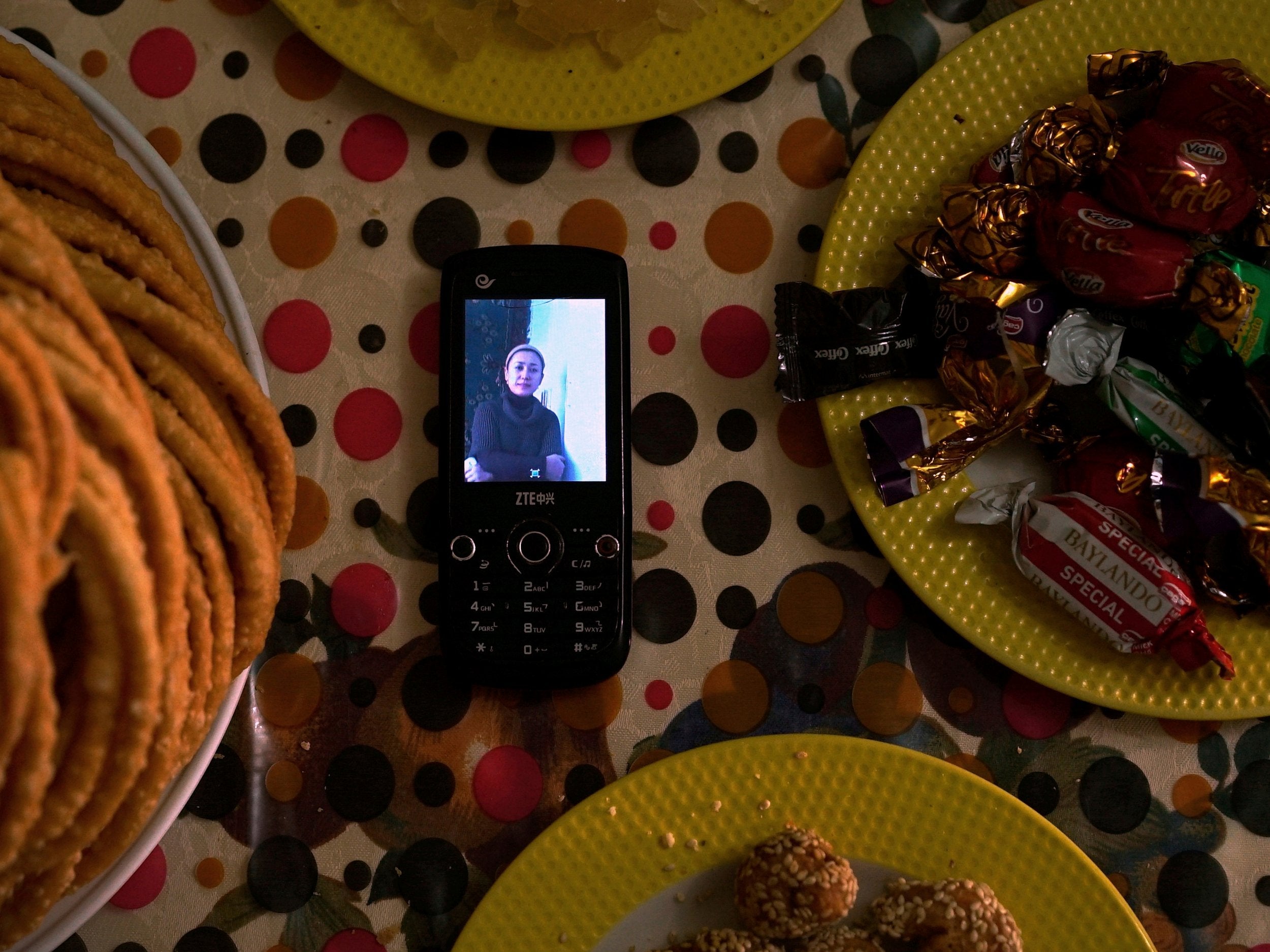 A phone displaying an image of Gulzar Seley, who was detained in China along with her newborn son, is placed on a table in the home of her husband Halmurat Idris in Istanbul