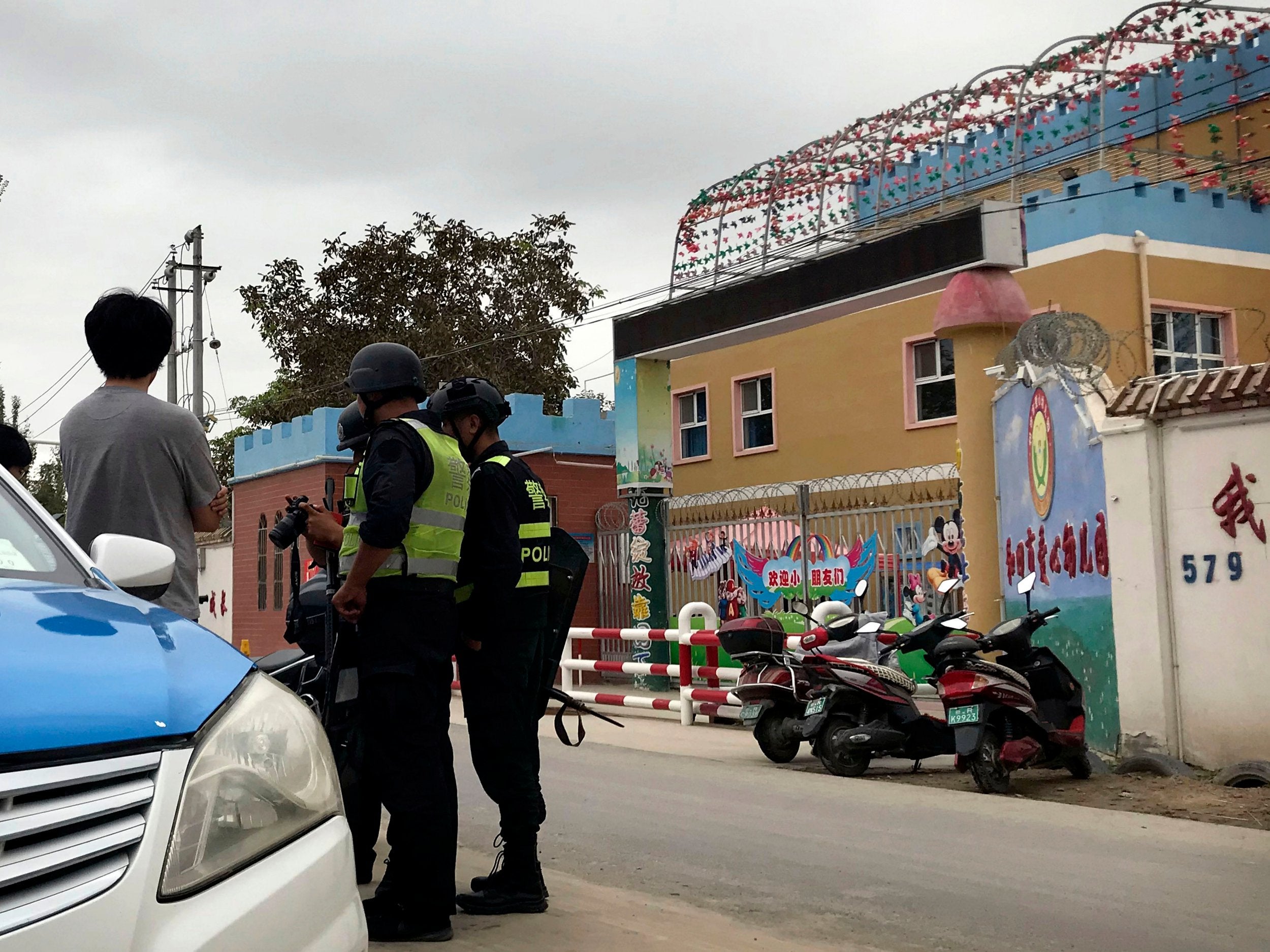 File photo: Security inspect camera equipment of journalists outside the Hotan City Kindness Kindergarten