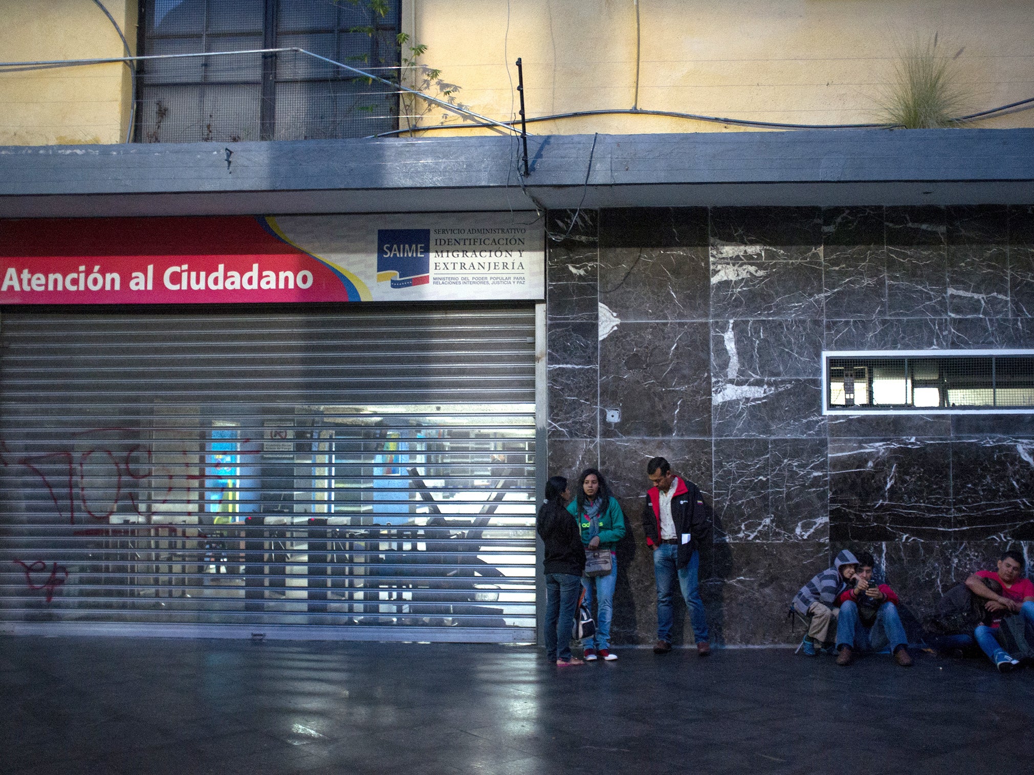 People wait in line outside Saime offices in Caracas