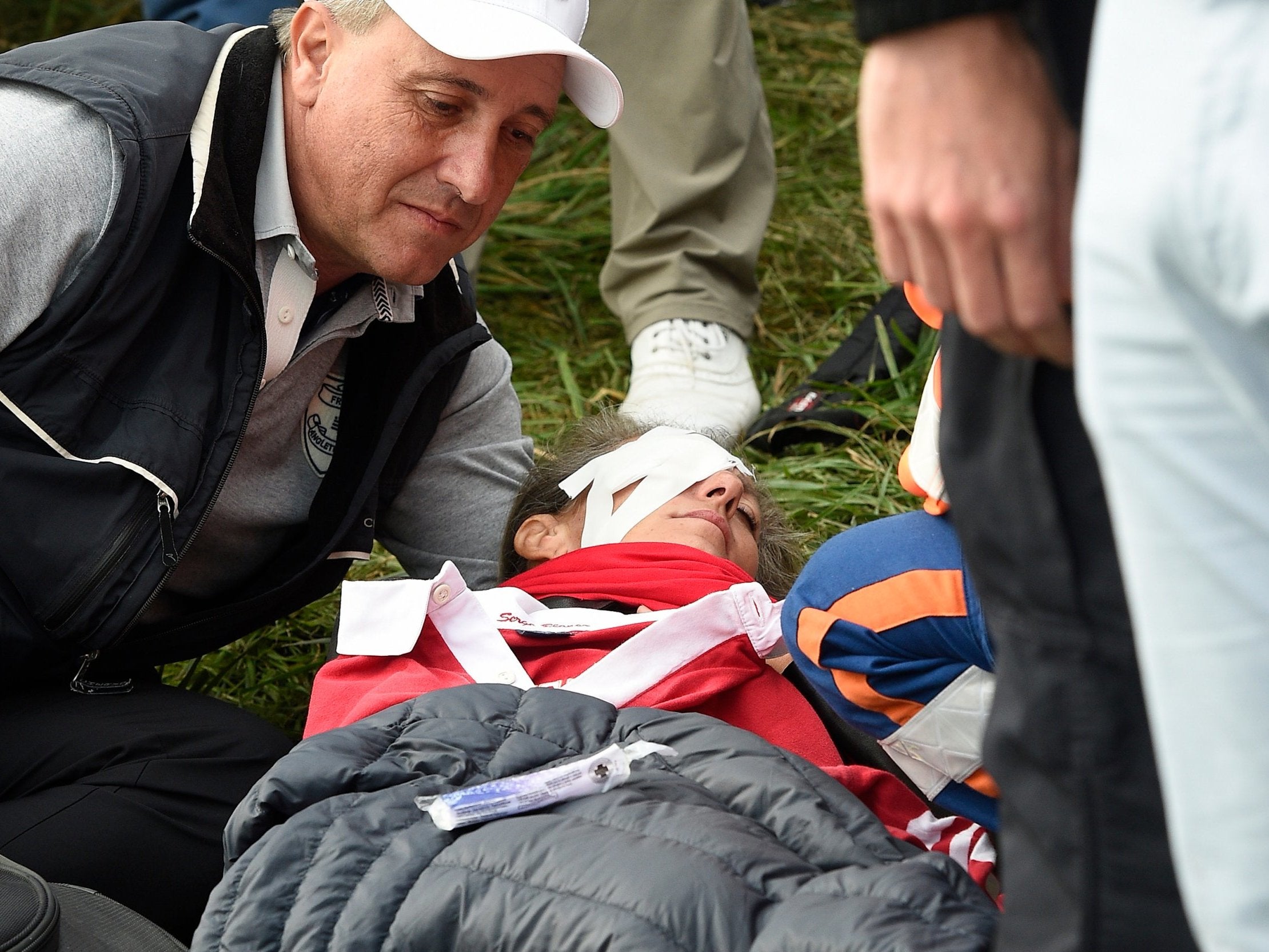 A spectator receives medical treatment after being hit by Koepka's shot