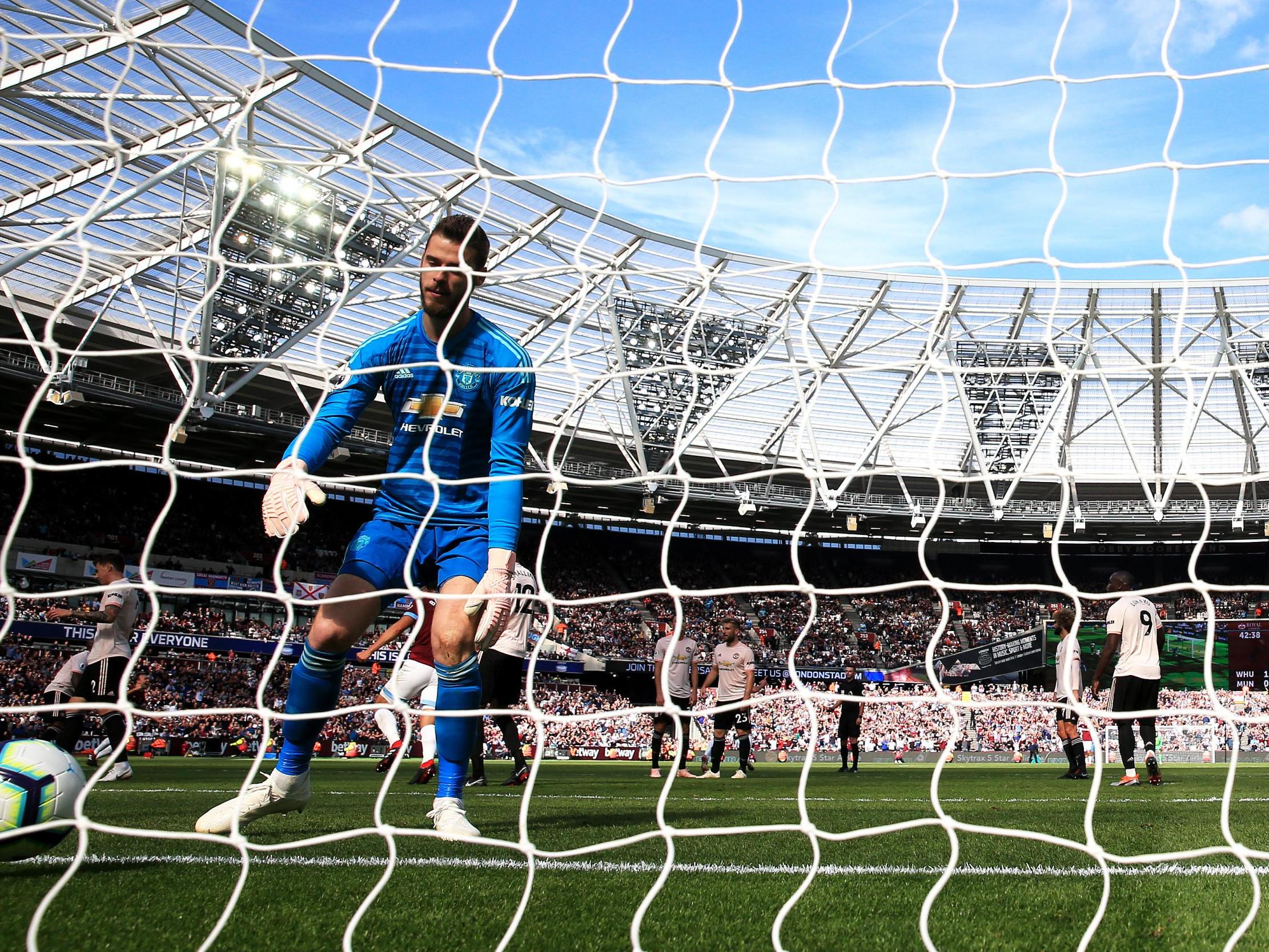 David De Gea retrieves the ball from his net after conceding from a Yarmolenko shot