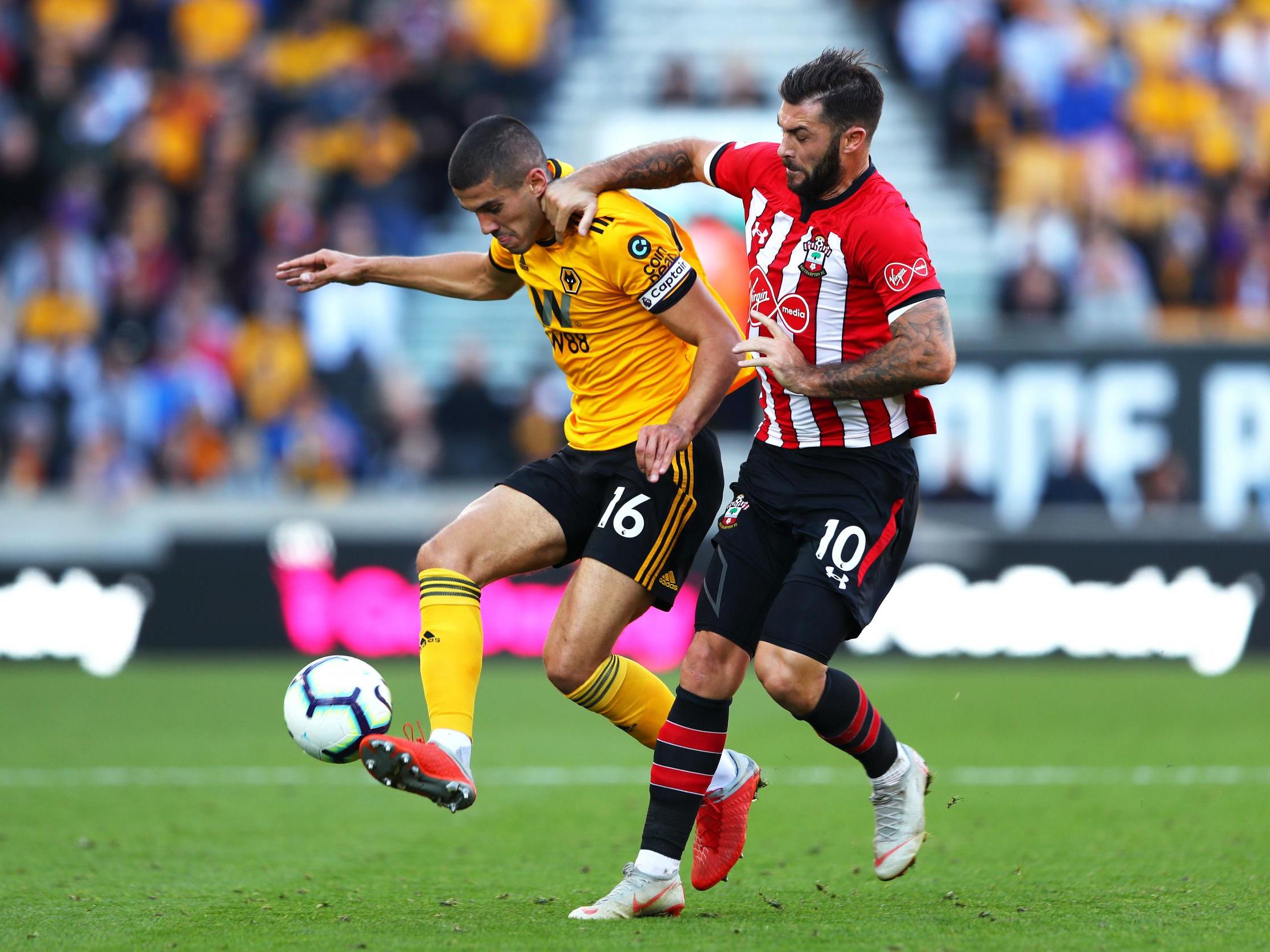 Conor Coady challenges for the ball with Charlie Austin