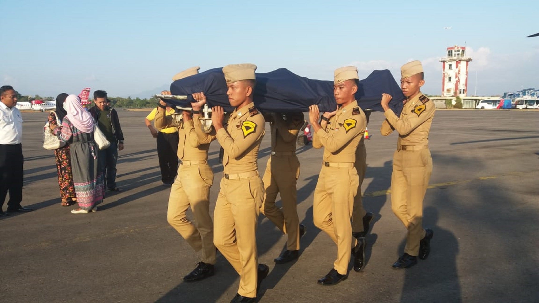 Soldiers carry the body of Anthonius Gunawan Agung, a 21-year-old air traffic controller who died after staying behind to make sure a passenger plane took off safely when a 7.5-magnitude earthquake hit the city of Palu, in Indonesia