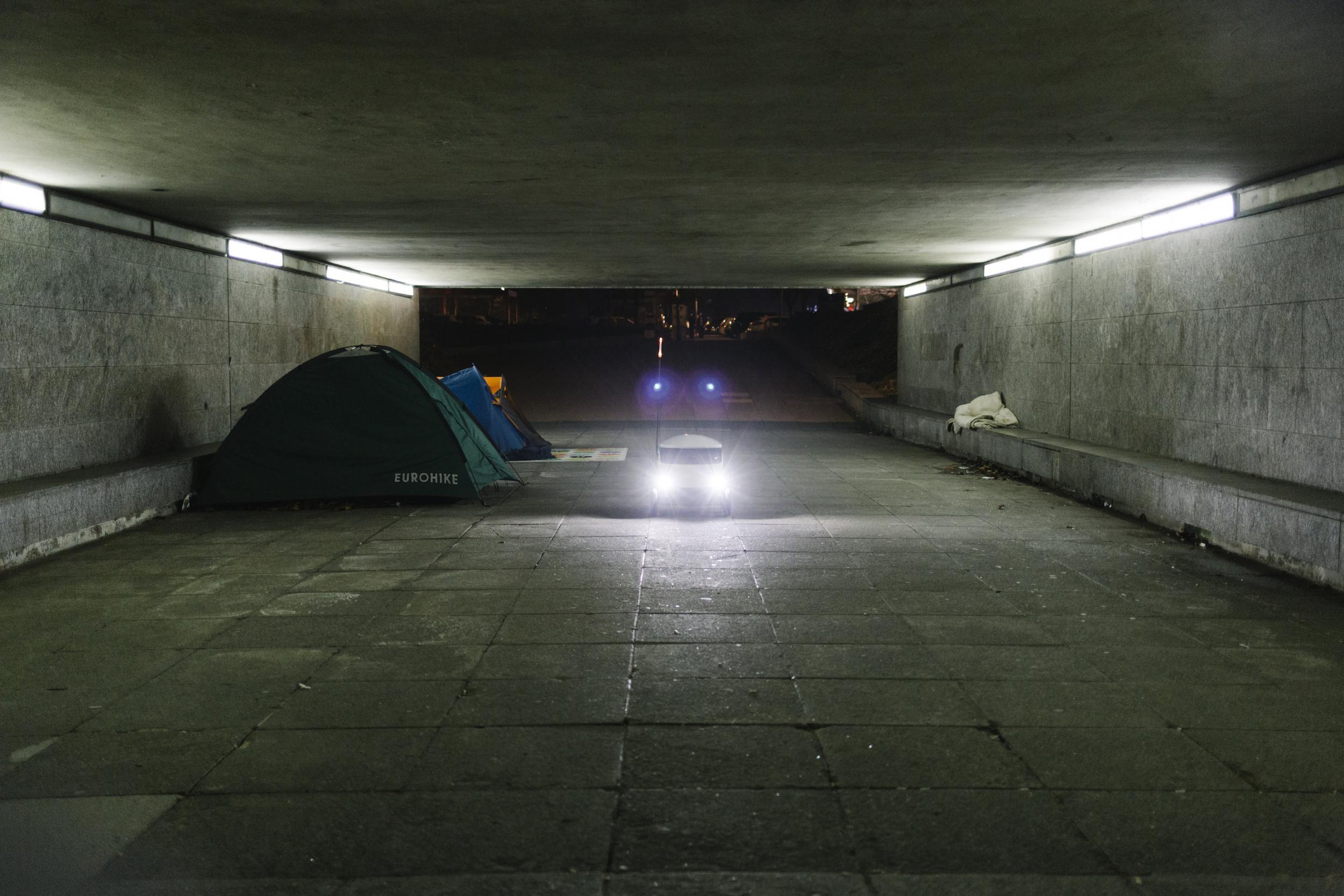 High-tech takeaway food delivery robots passing tents is a familiar yet jarring sight