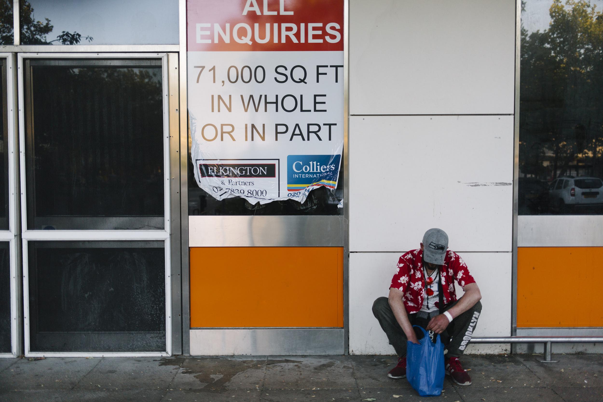 A homeless man opens a bag of food from the daily soup kitchen. There is an estimated one million square foot of empty commercial space in Milton Keynes