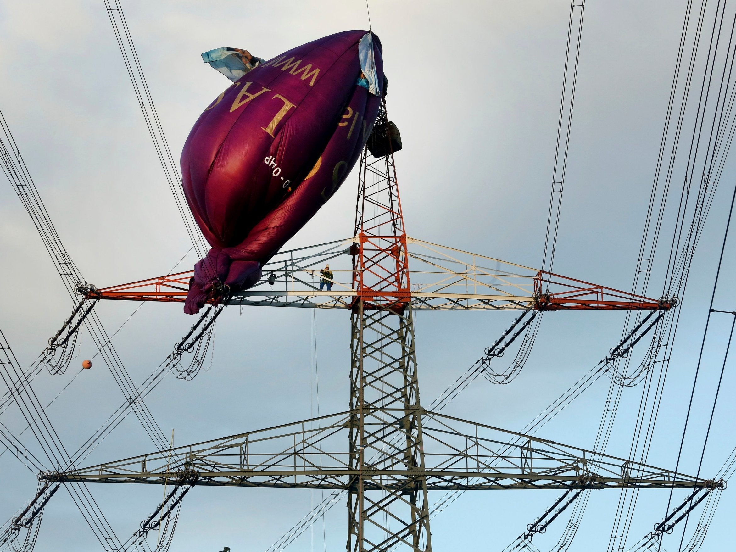 A hot air balloon hangs on top of a high-voltage power line in Bottrop