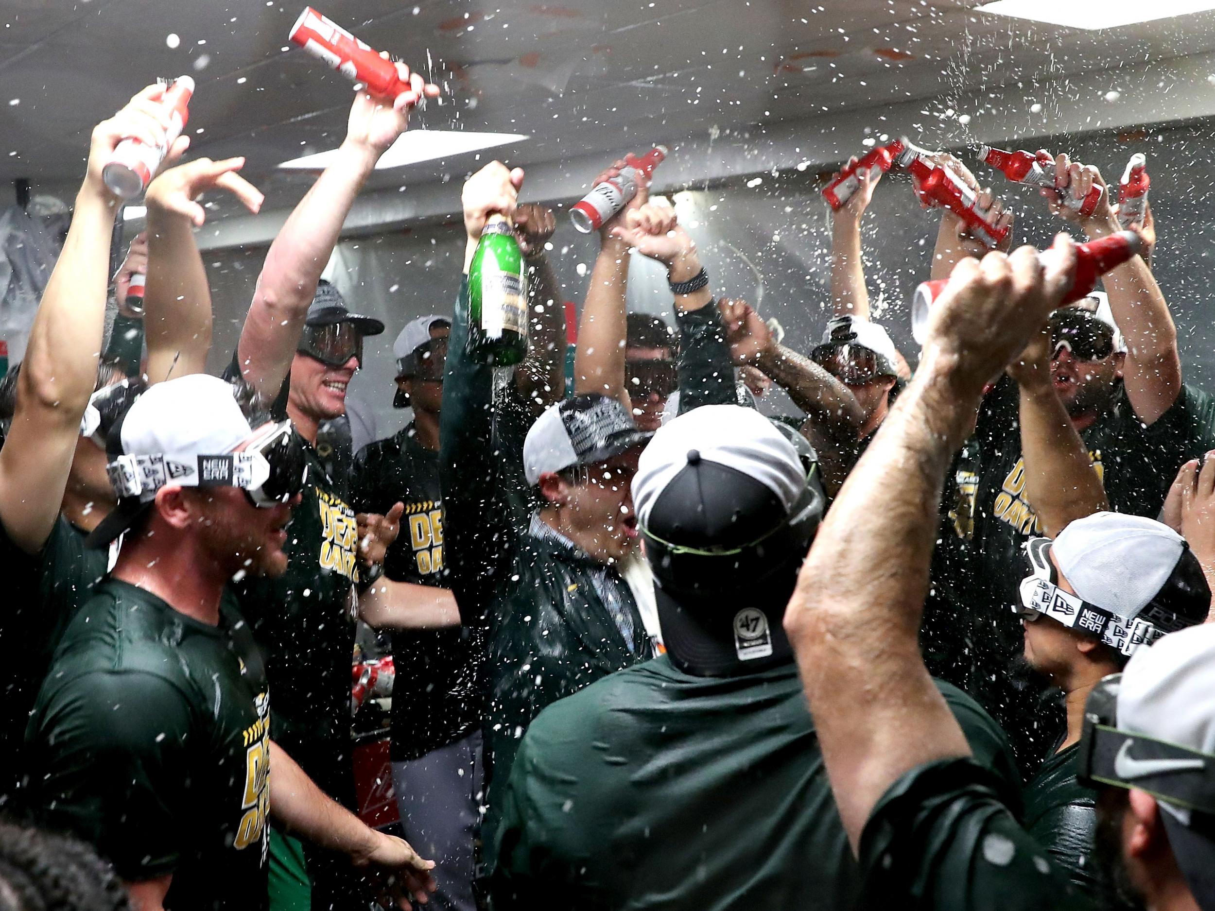 Oakland Athletics players celebrate clinching a spot in the playoffs after beating the Seattle Mariners