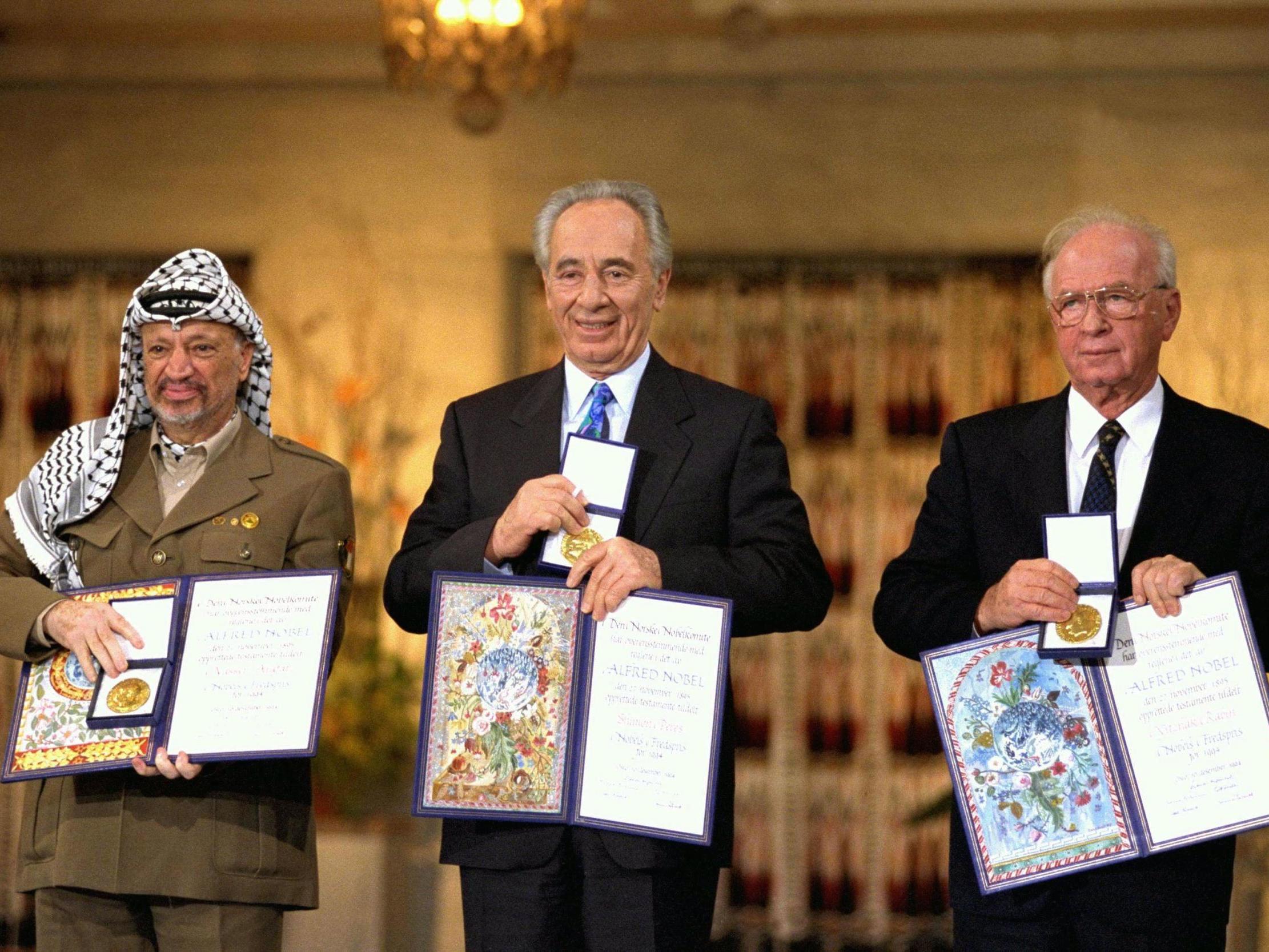 Palestinian leader Yasser Arafat, Israeli foreign minister Shimon Peres and Israeli premier Yitzhak Rabin display their Nobel Peace Prizes in 1994