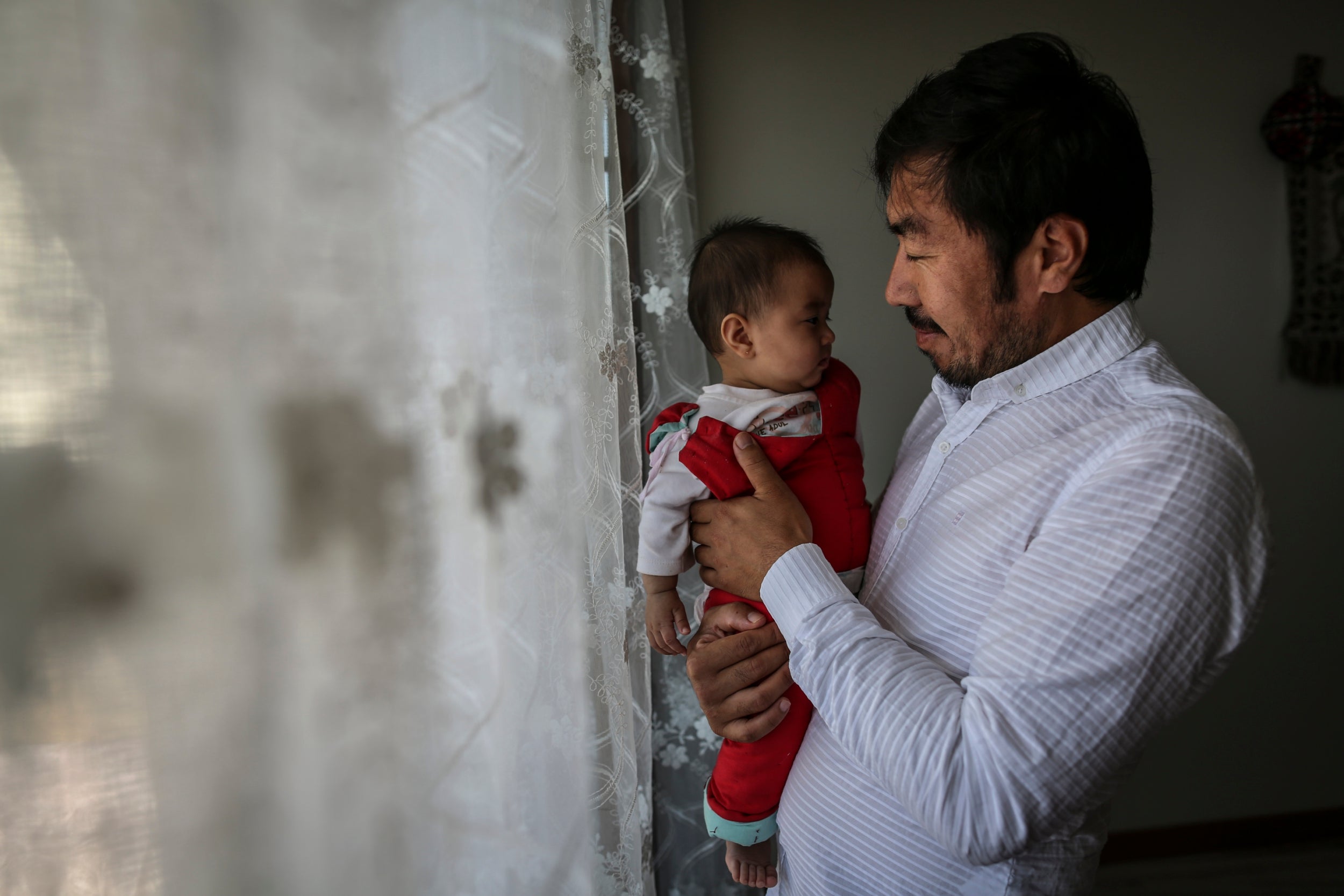 Eysa, a Chinese ethnic Uighur, with his child at their home in Istanbul.