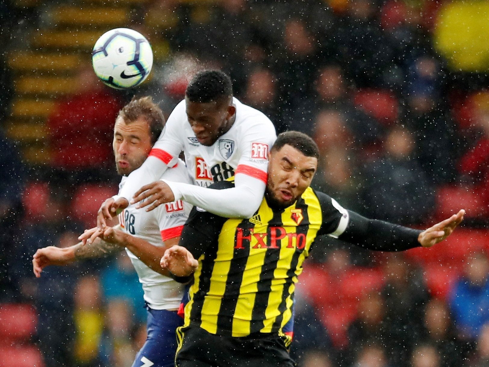 Troy Deeney battles two Bournemouth defenders