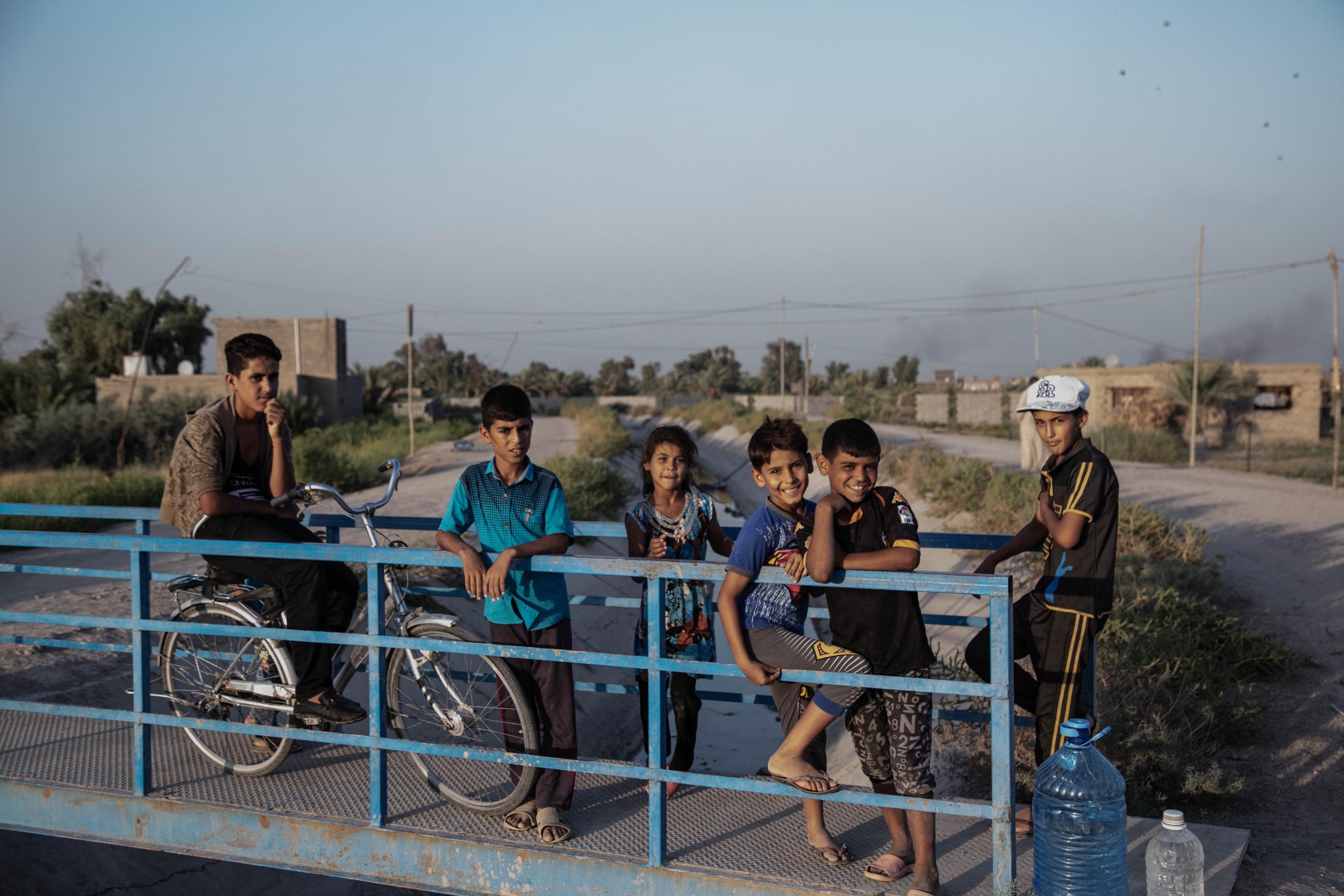 Children from a farming community play by dried up river beds and canals south of Baghdad