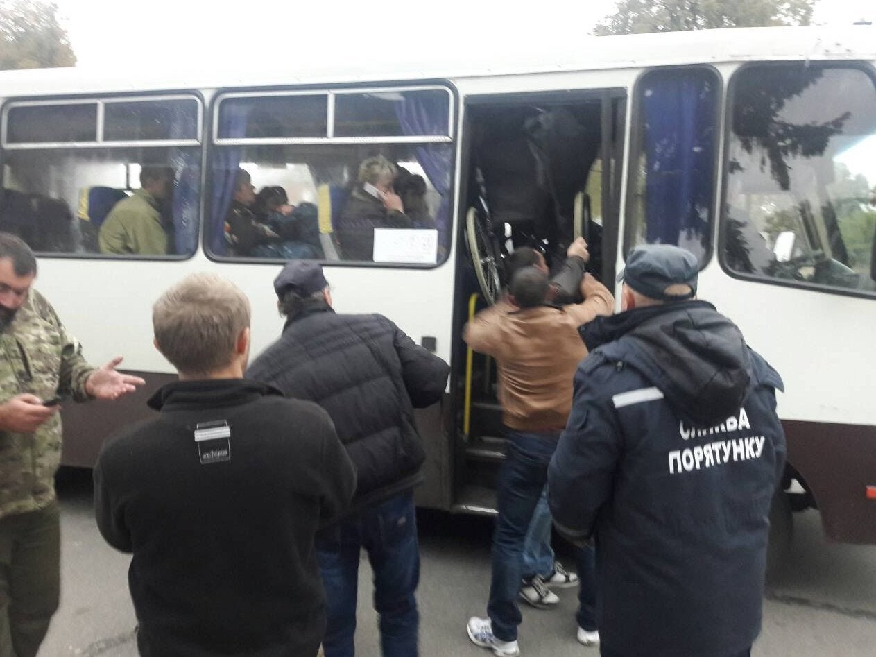 Emergency workers evacuate residents in the settlement of Druzhba