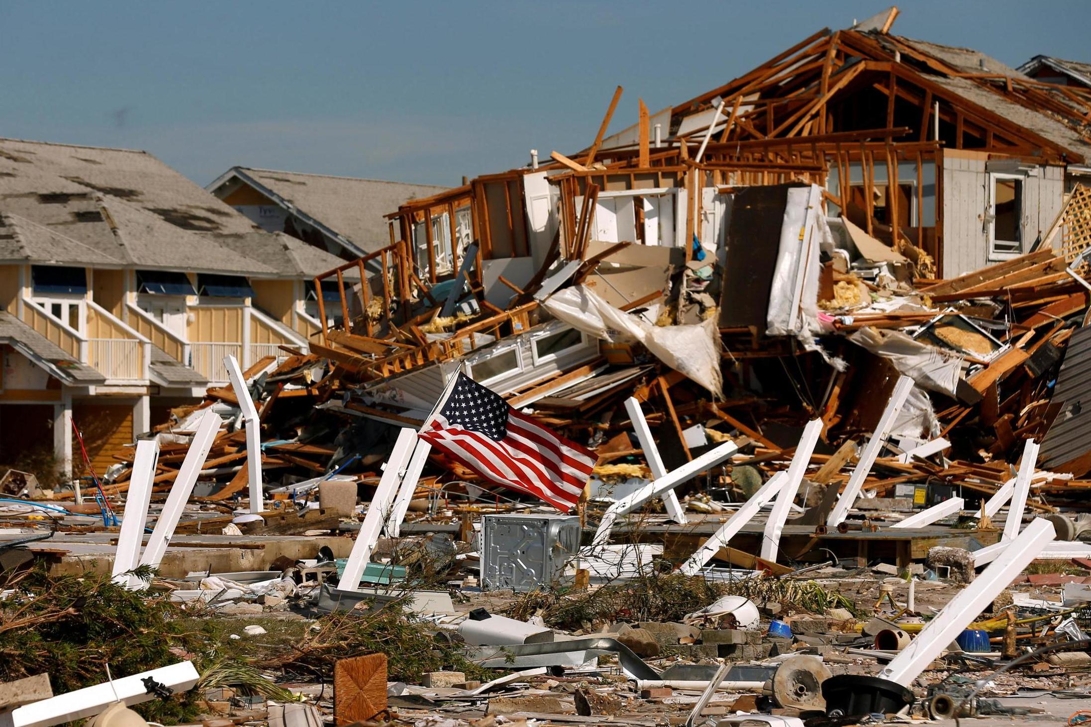 An American flag flies amongst rubble left in the aftermath of Hurricane Michael in Mexico Beach