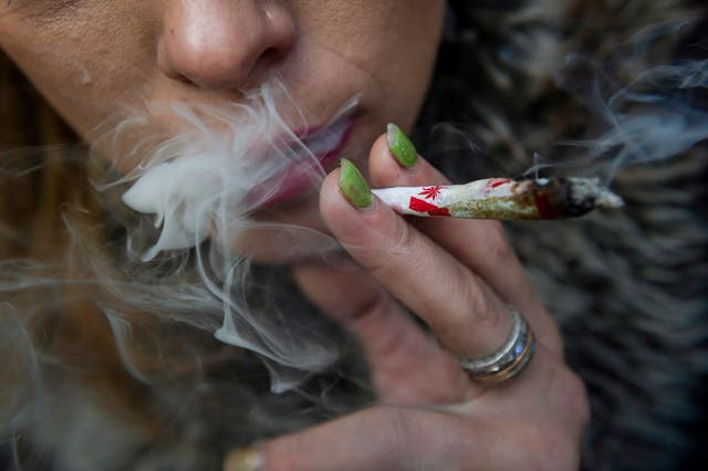 Krissy Calkins smokes a marijuana joint at a "Wake and Bake" legalized marijuana event in Toronto. Canada became the largest country with a legal national marijuana marketplace as sales began early Wednesday in Newfoundland