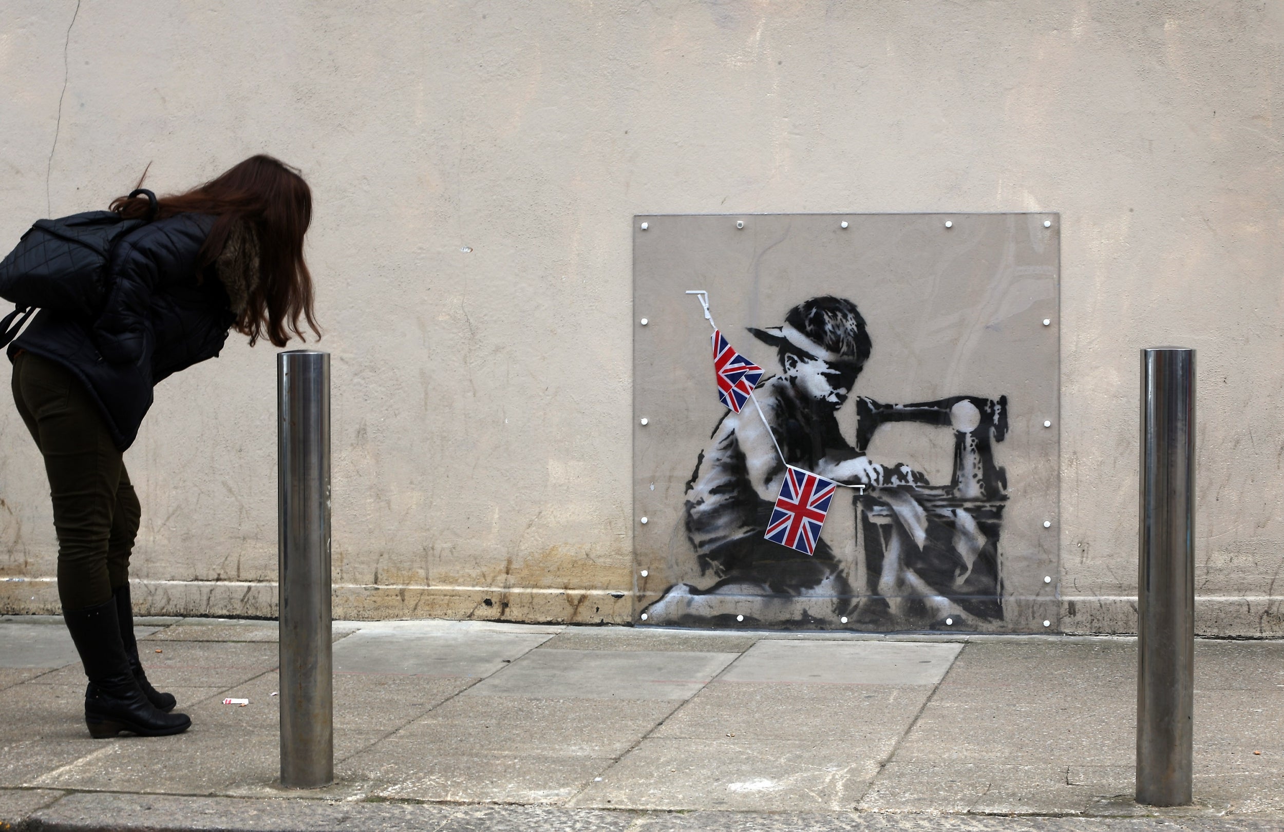 The former piece - Slave Labour (Bunting Boy) - which was attributed to Banksy - appeared on the same wall 10 years ago