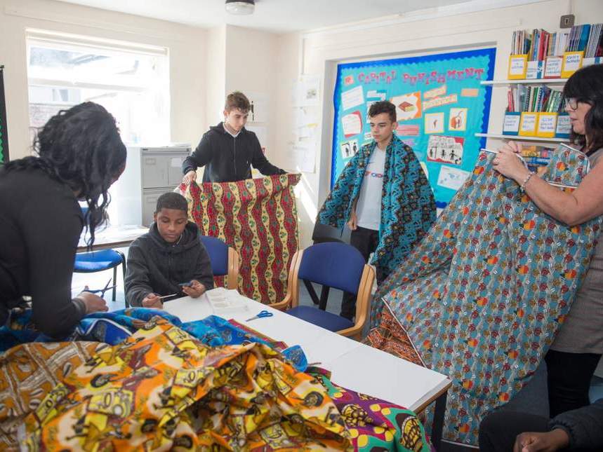 Students at Francis Barber Referral Unit in Wandsworth examine fabrics sent by children from Bangui