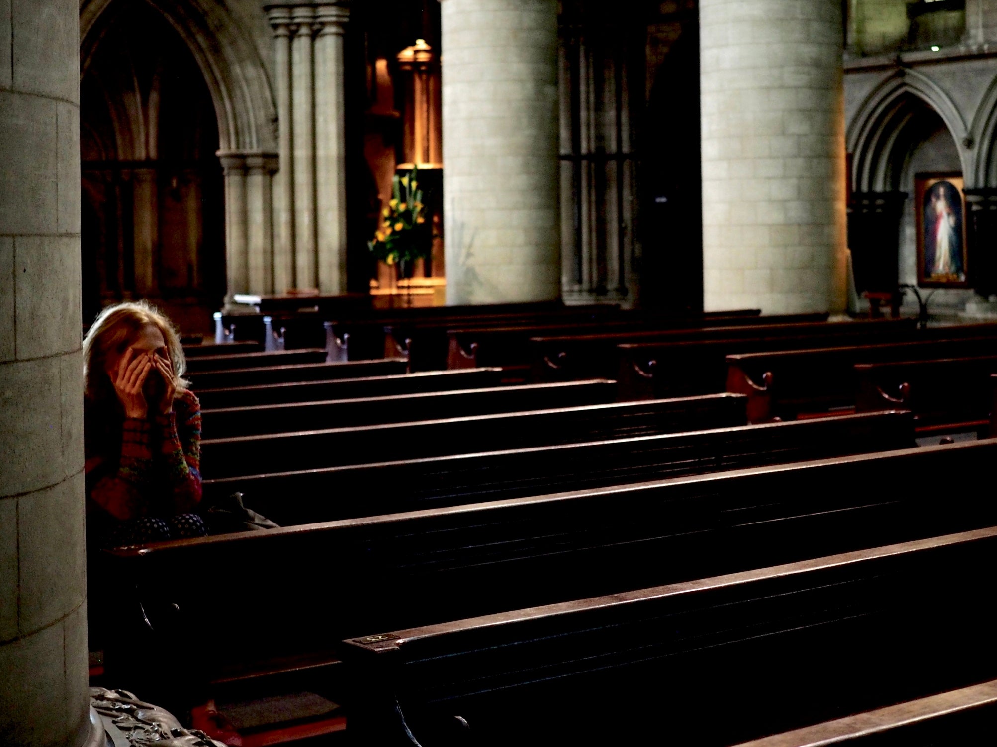 A woman during mass in Norwich cathedral