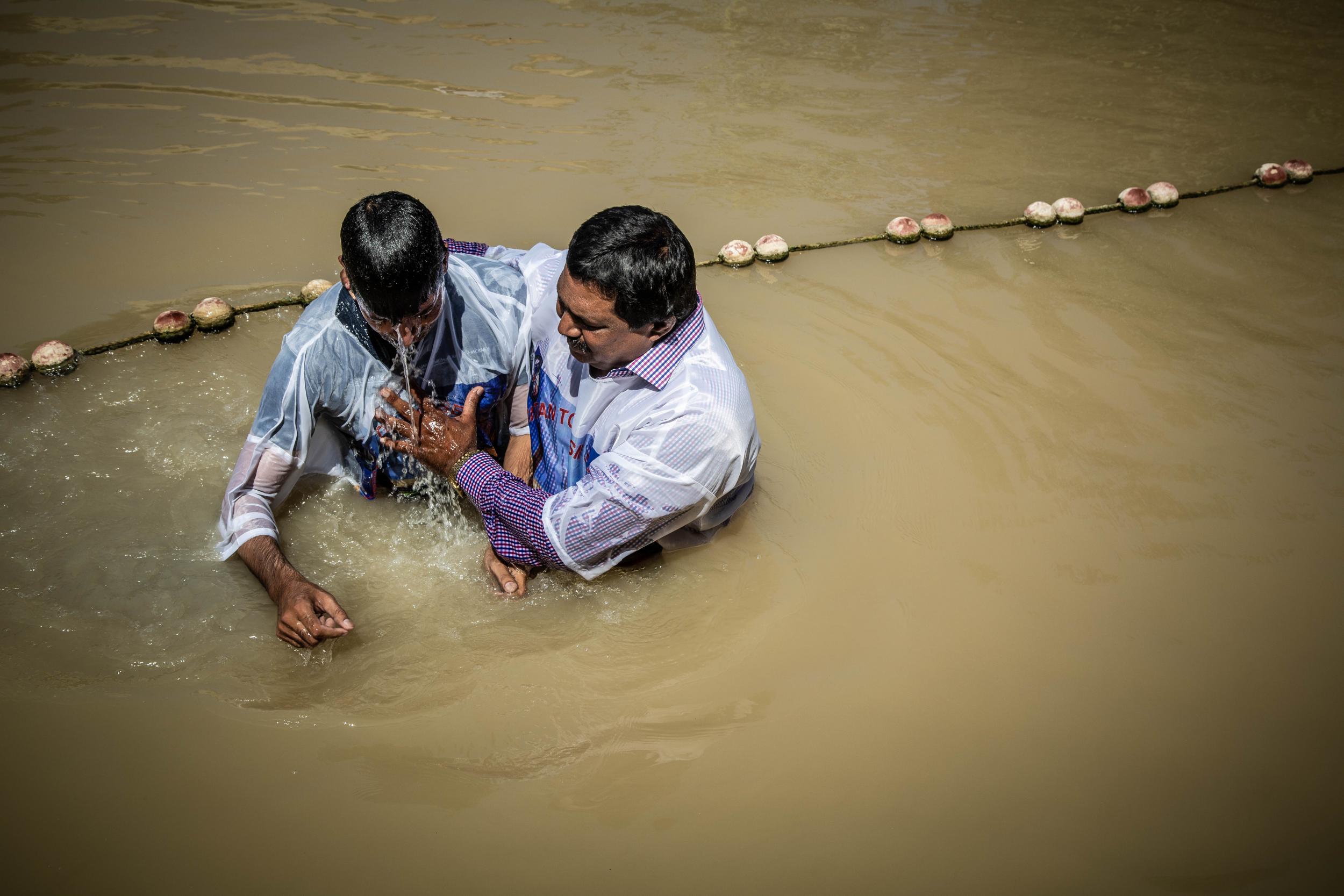 Worshippers go through baptismal rites on the Jordanian side of the River Jordan